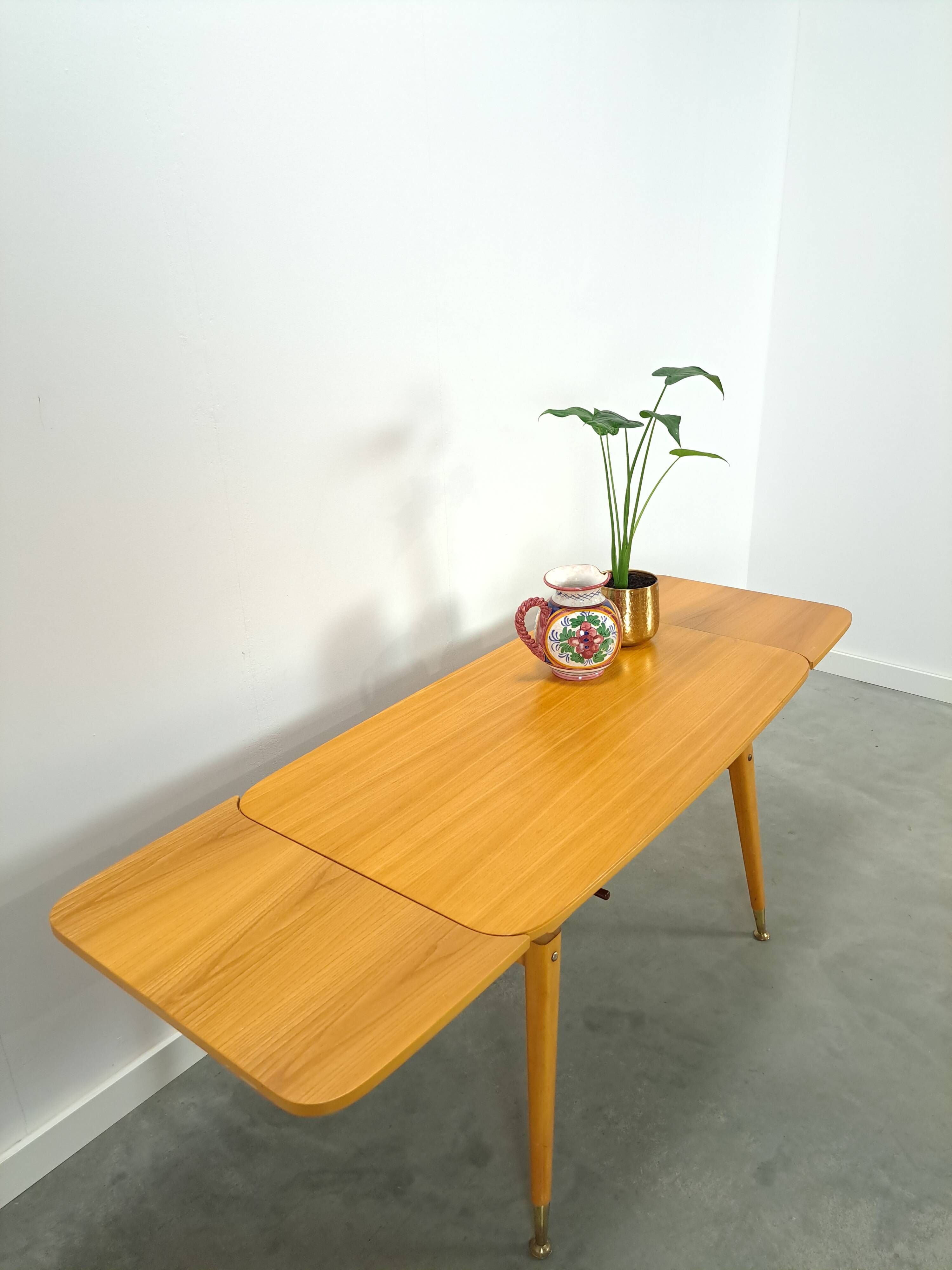 Vintage veneer table with pretty angular legs and brass at the base of the legs.