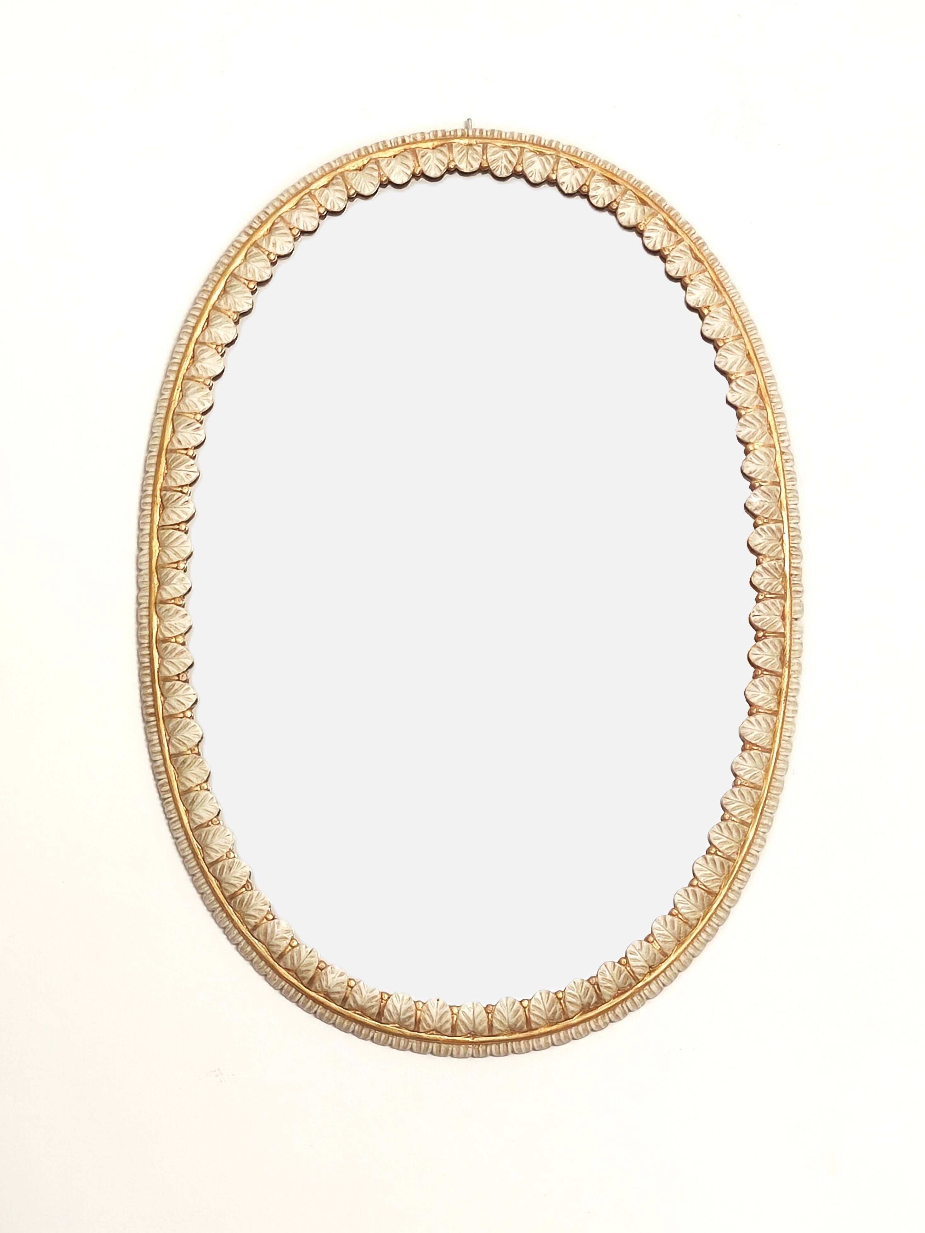 Large oval Florentine mirror in carved wood and gilded with gold leaf.