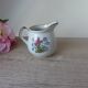 Vintage handmade speckled stoneware milk jug with floral design from the 1980s.