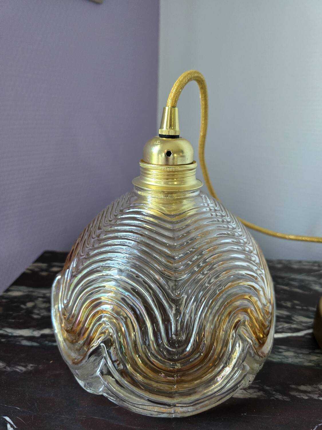 Suspension with amber moulded glass globe featuring wavy patterns.