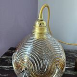 Suspension with amber moulded glass globe featuring wavy patterns.