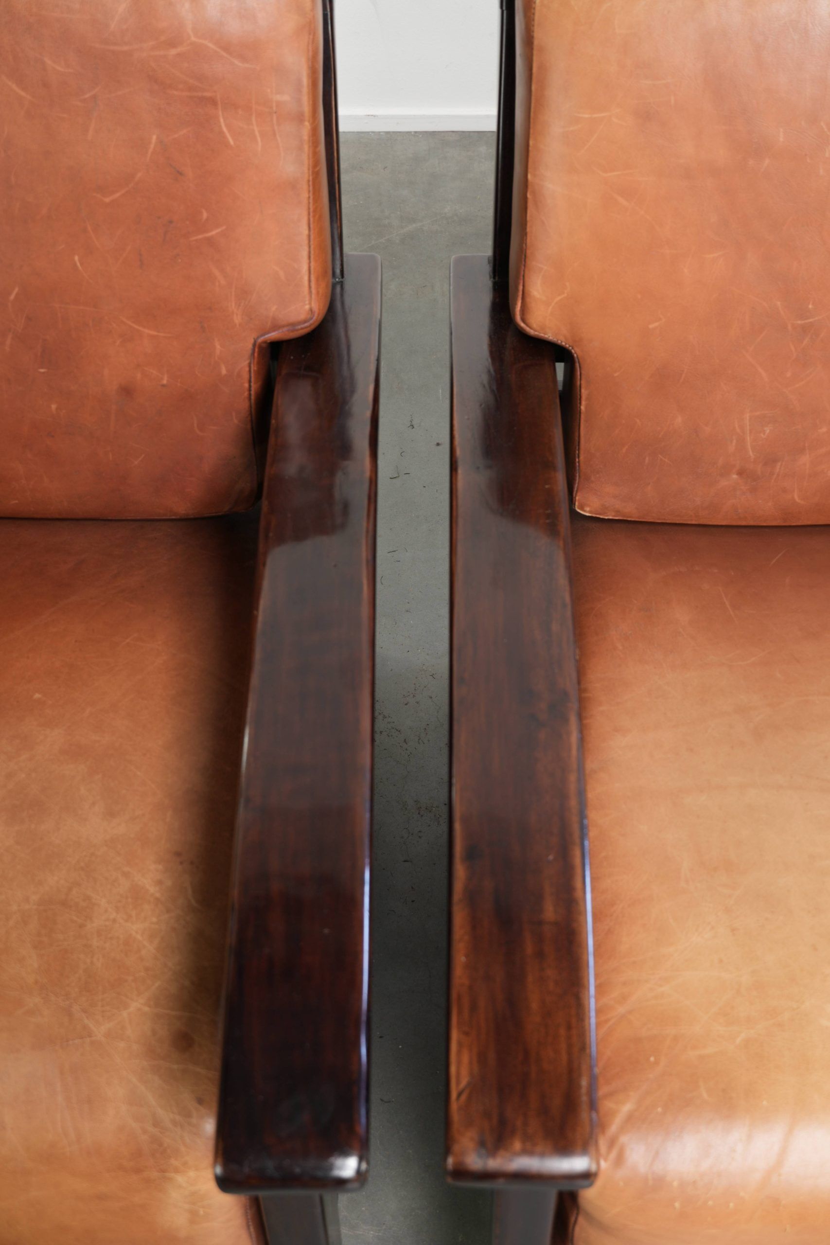 Ensemble de 2 fauteuils Art Déco en cuir de vache couleur cognac du 20e siècle.