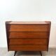 Vintage wooden chest of drawers with tapered legs.