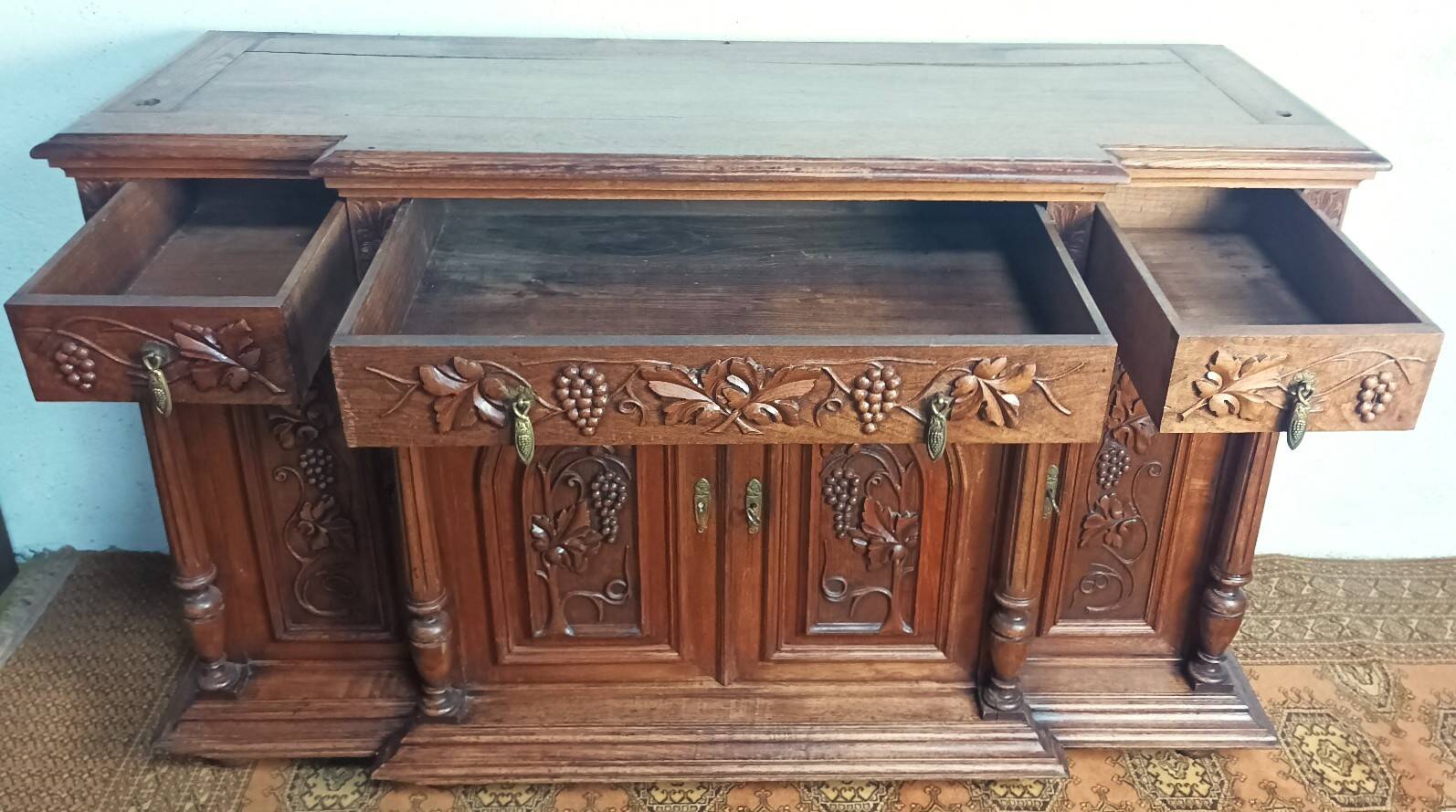 Art Nouveau buffet in carved oak with grapevine cluster decoration.