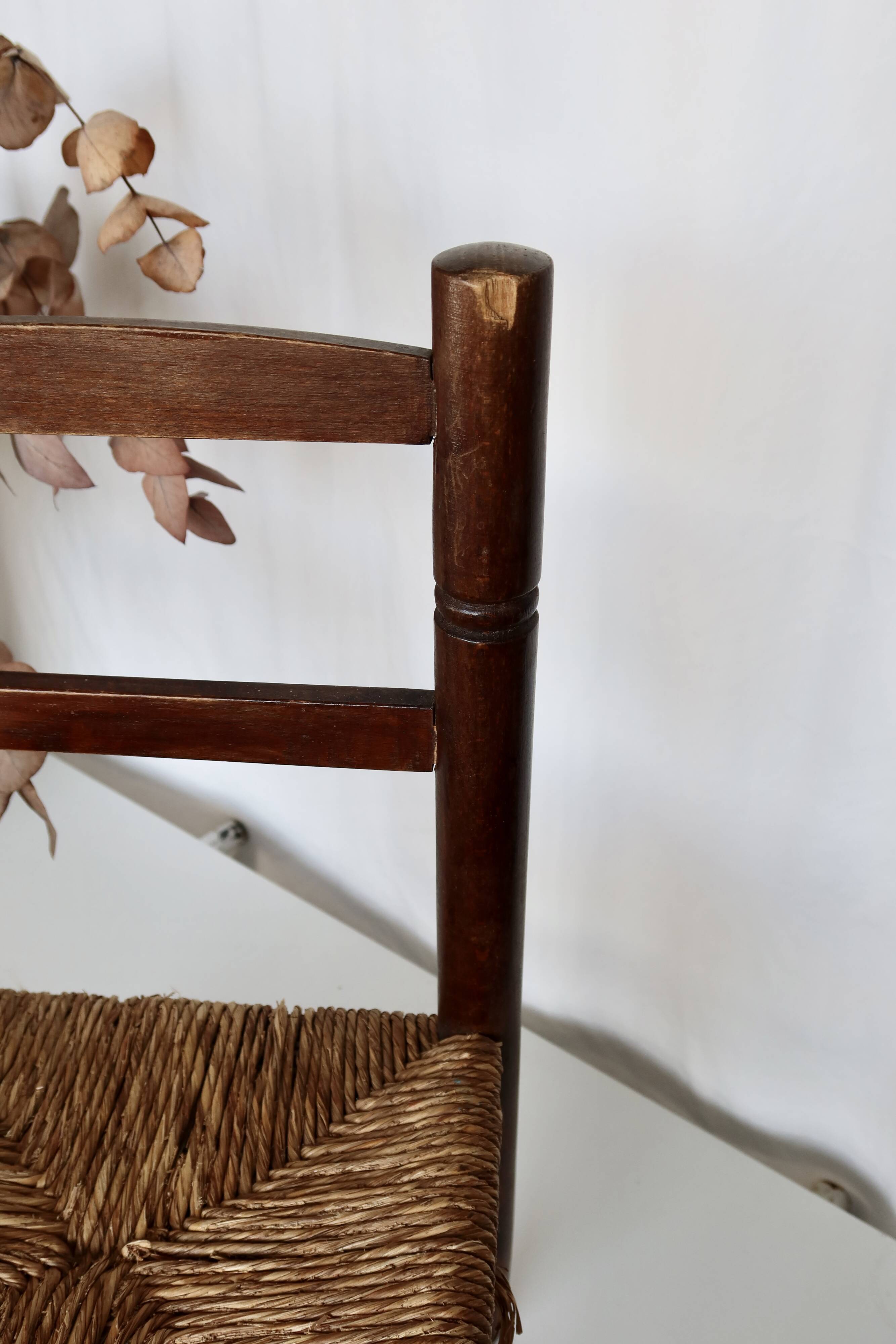 Vintage children's chair in dark wood with woven straw seat