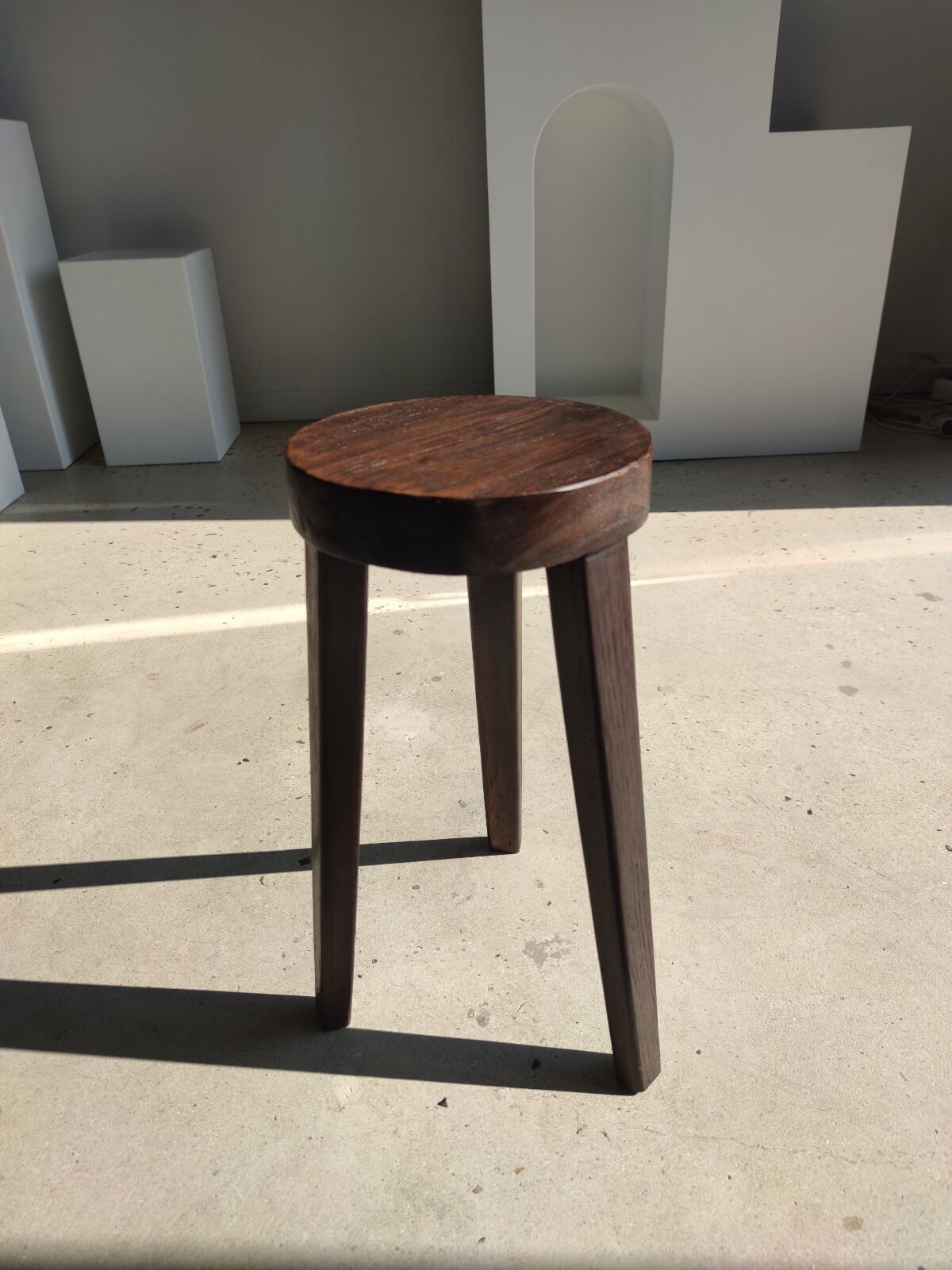 Small high tripod stool in brown solid wood