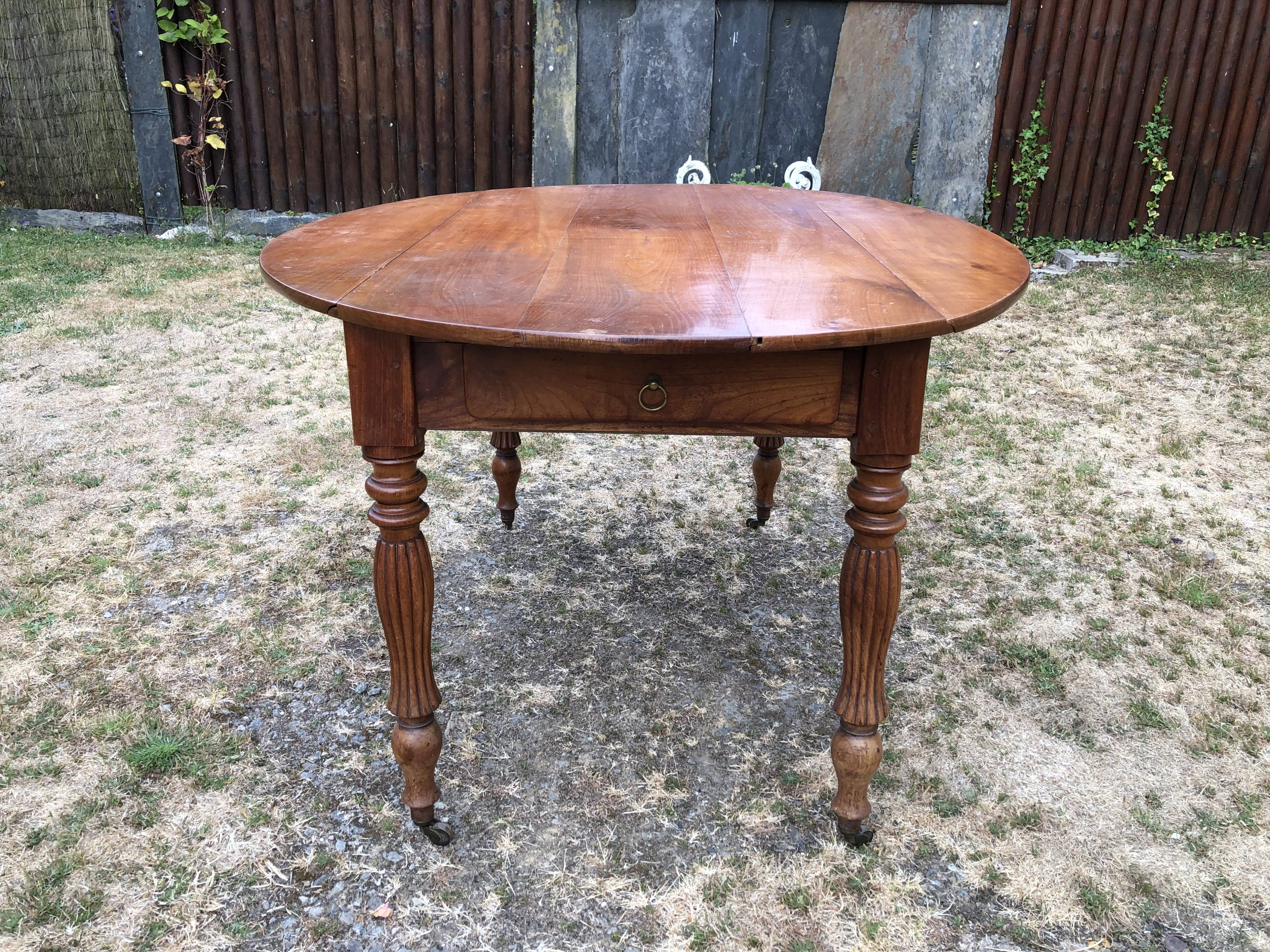 Louis Philippe oval drop-leaf table in solid cherry wood with 2 drawers.