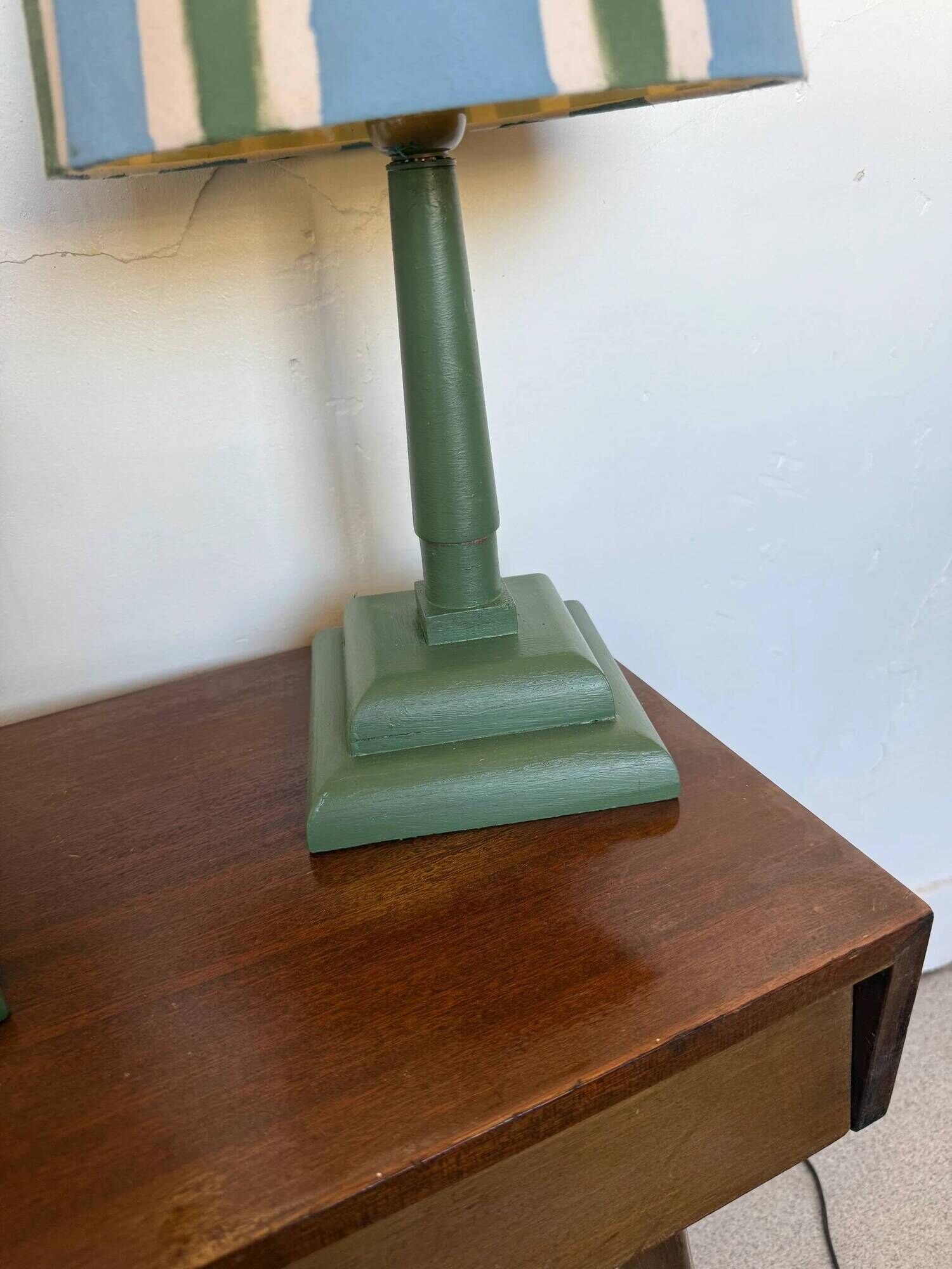 Pair of vintage wooden lamps with their striped beige, blue, and green shades.