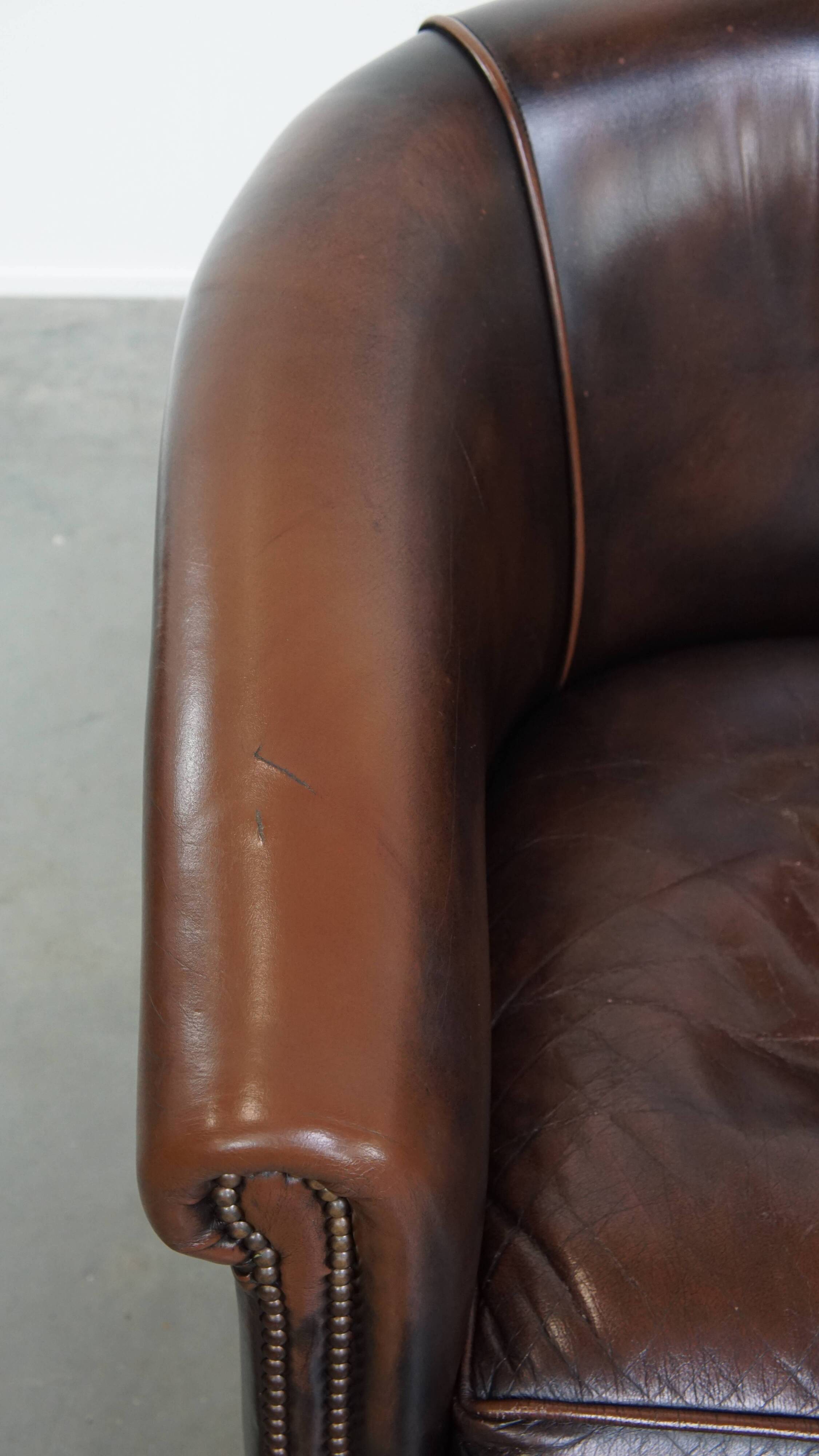 Fauteuil club de couleur foncée en cuir de vachette
