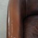 Fauteuil club de couleur foncée en cuir de vachette