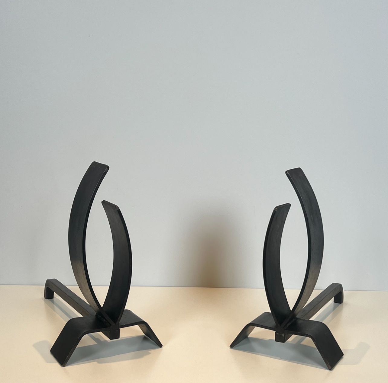 Pair of modernist andirons in steel and wrought iron