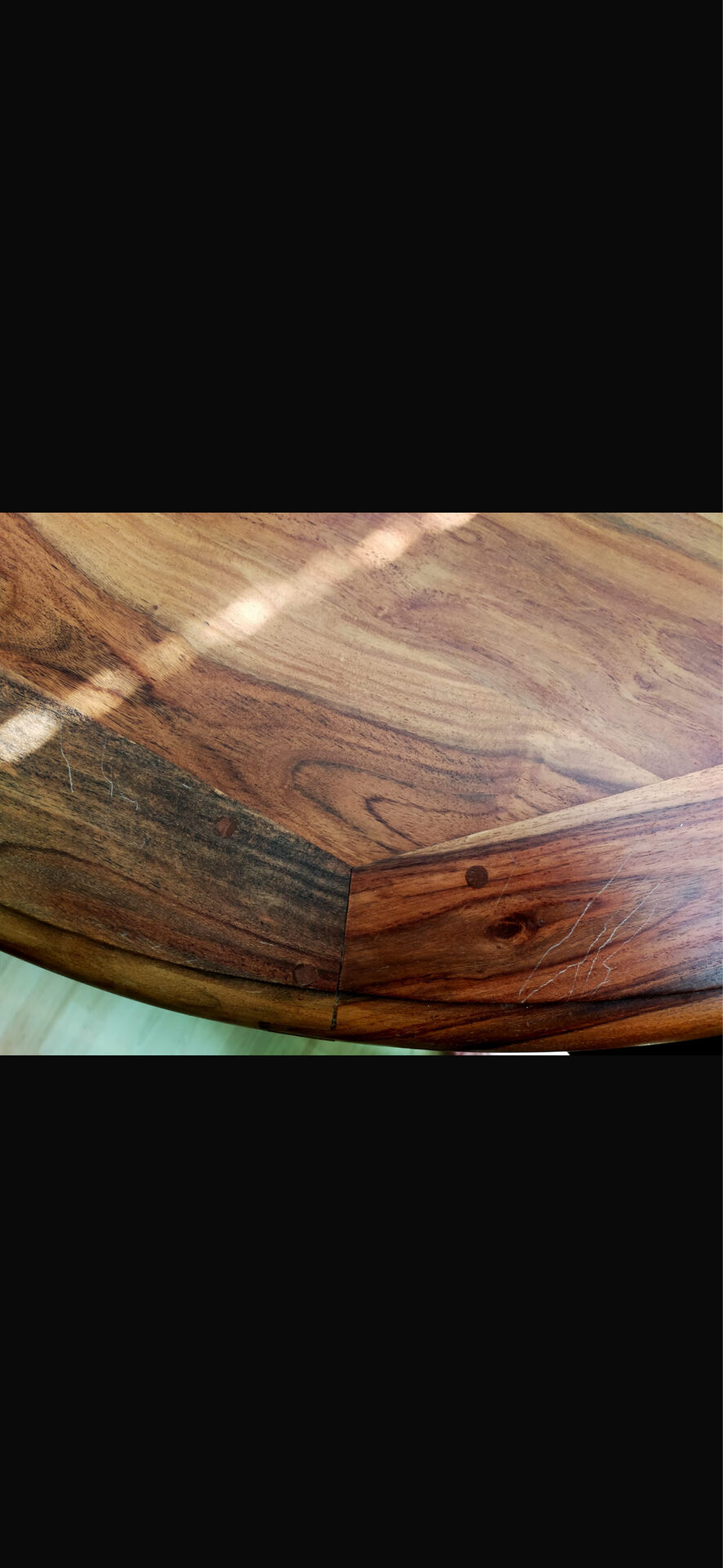 Round wooden table with wrought iron legs.