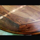 Round wooden table with wrought iron legs.