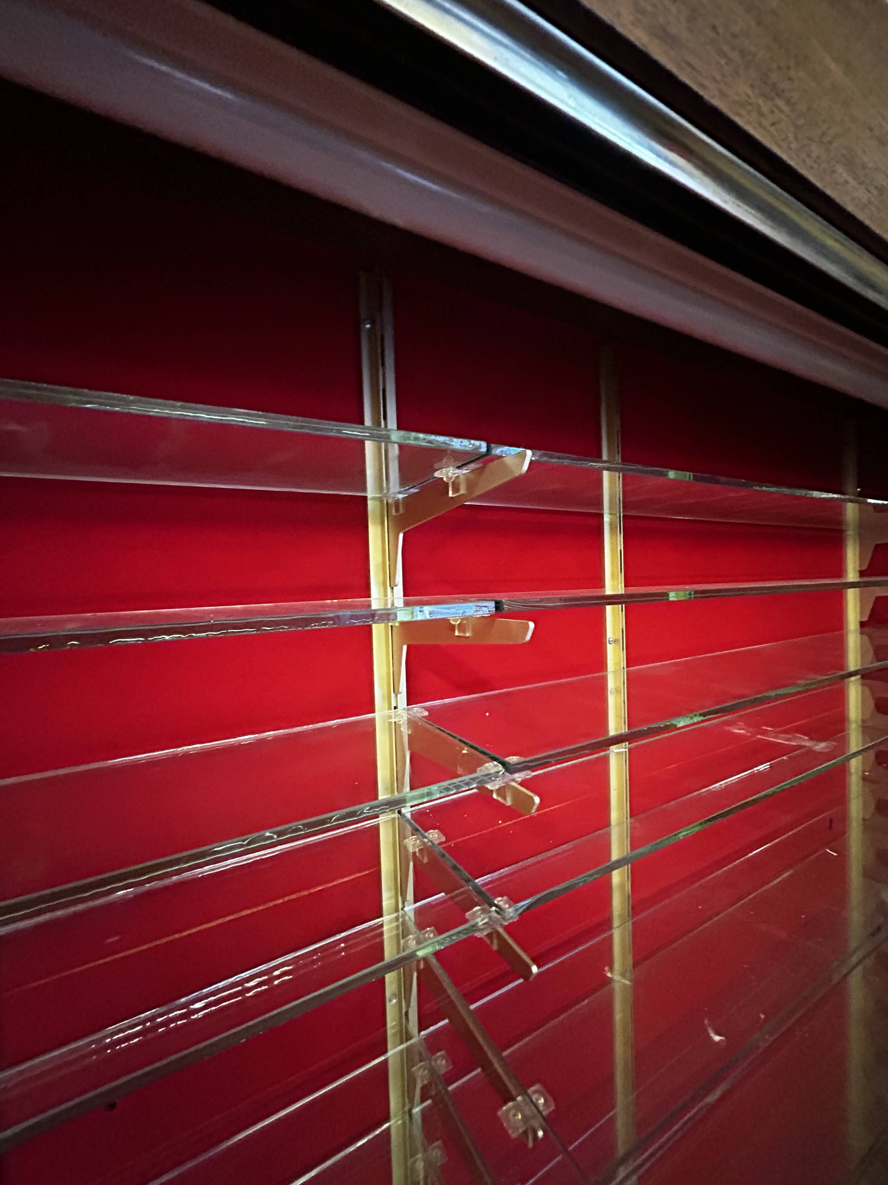 Large vintage display cabinet in wood and glass – red background, 15 shelves