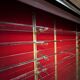Large vintage display cabinet in wood and glass – red background, 15 shelves