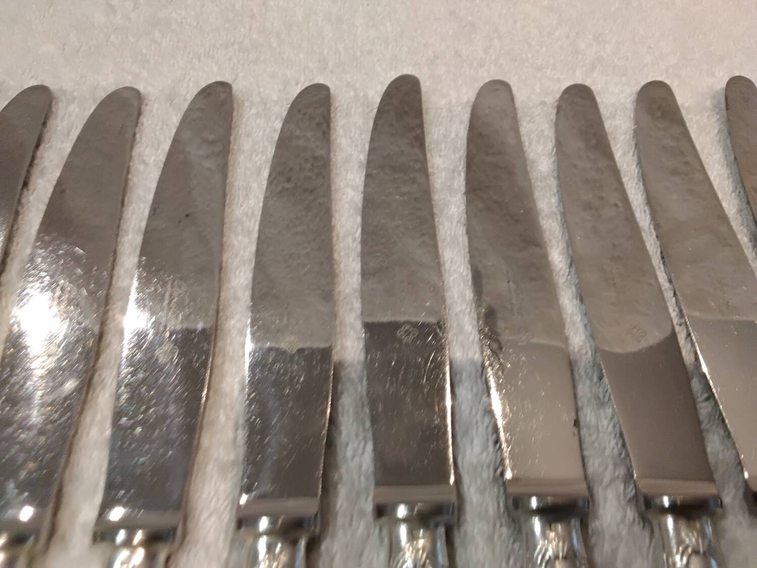 12 silver-plated table knives, Christofle goldsmith ribbons