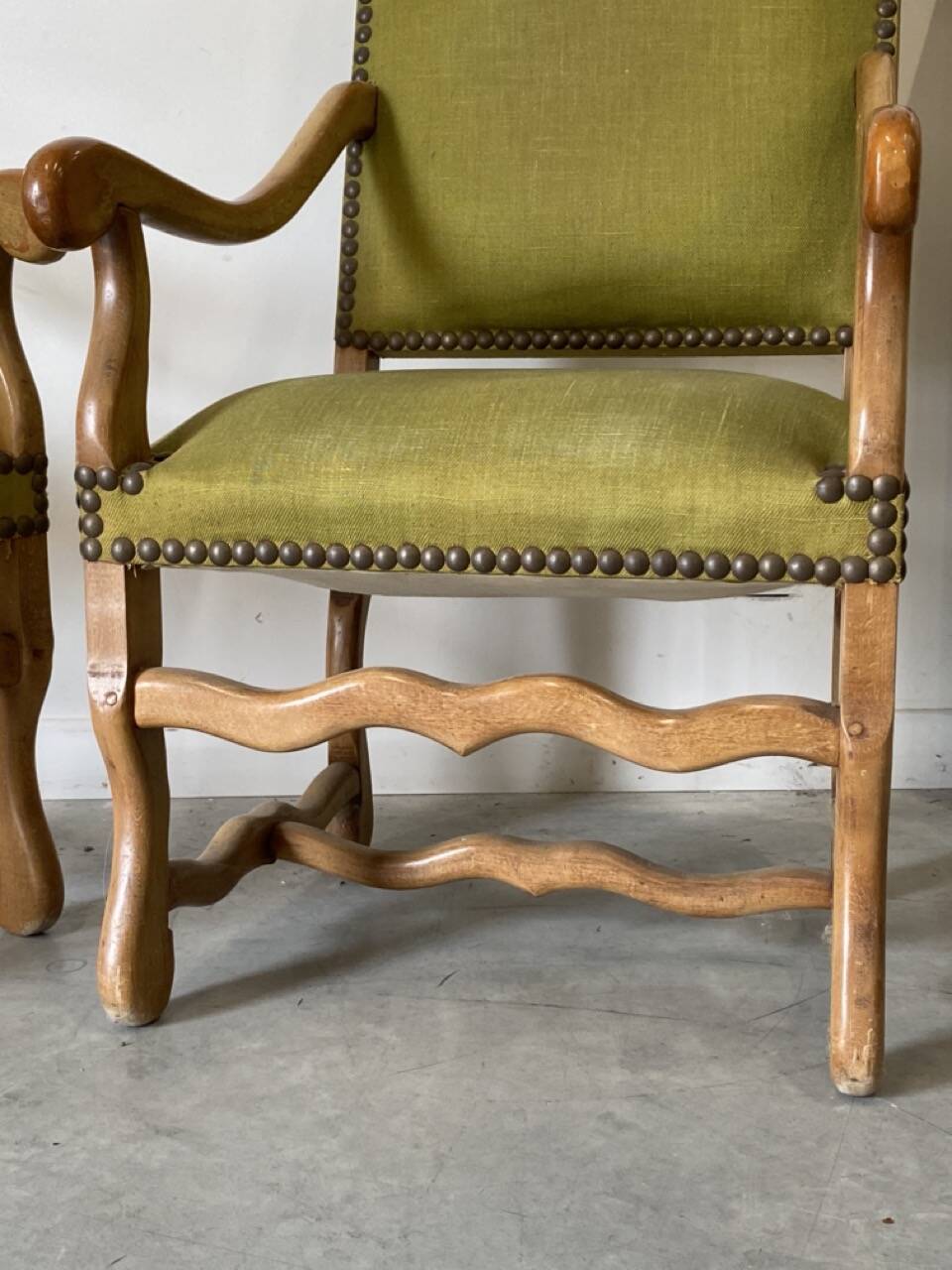 Olive green upholstered armchairs with studs