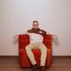 Burnt orange modular sofa for four with a futuristic design.