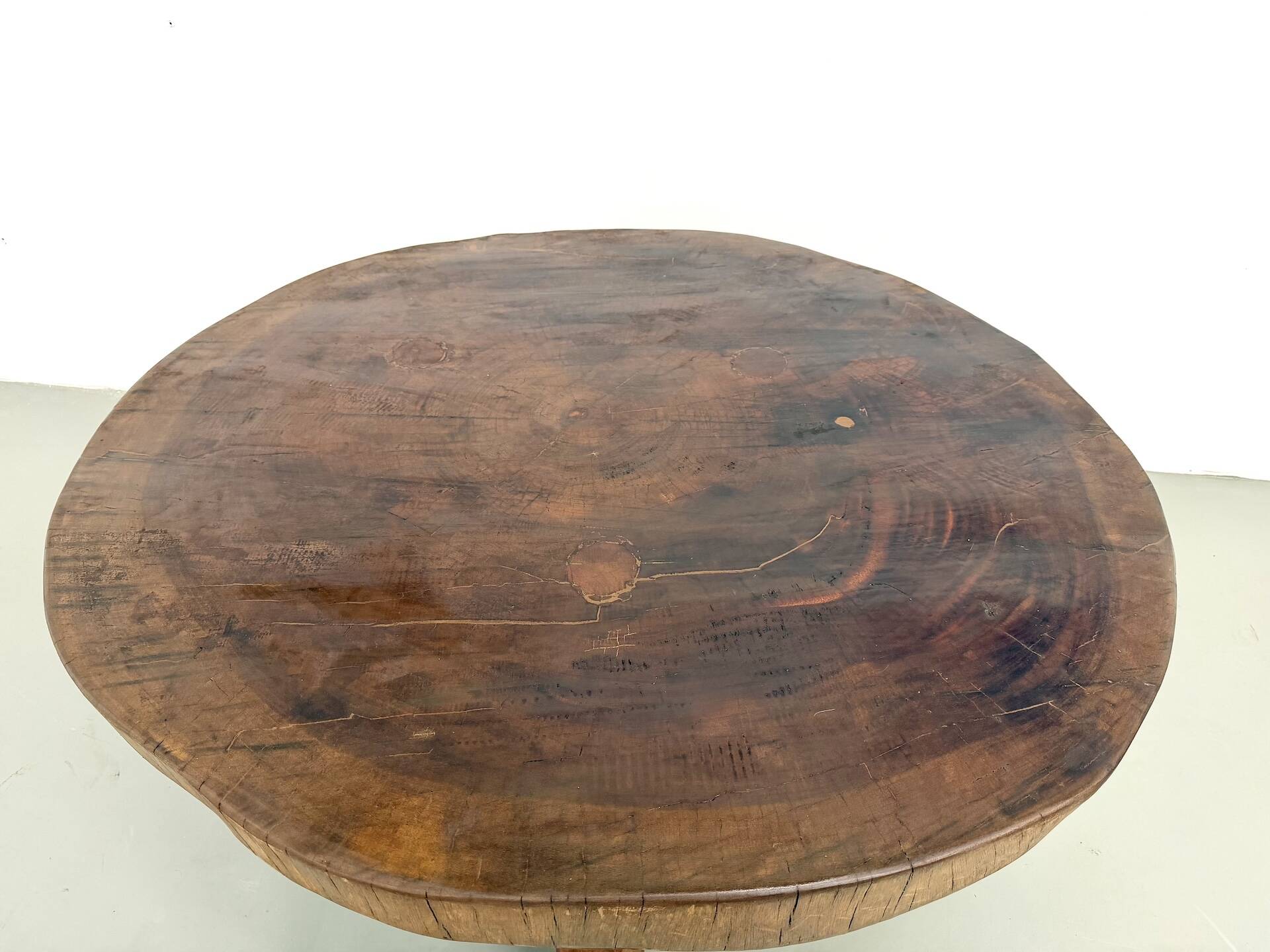 Brutalist coffee table in solid teak, monolithic slab, tripod base.