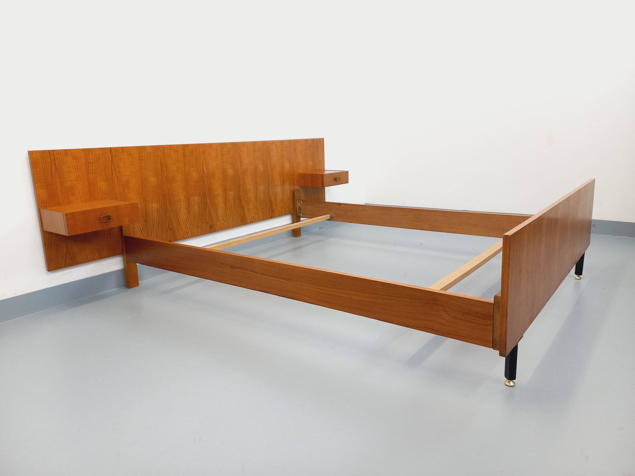 Double bed vintage modernist in teak and black metal from the 1960s with bedside tables.