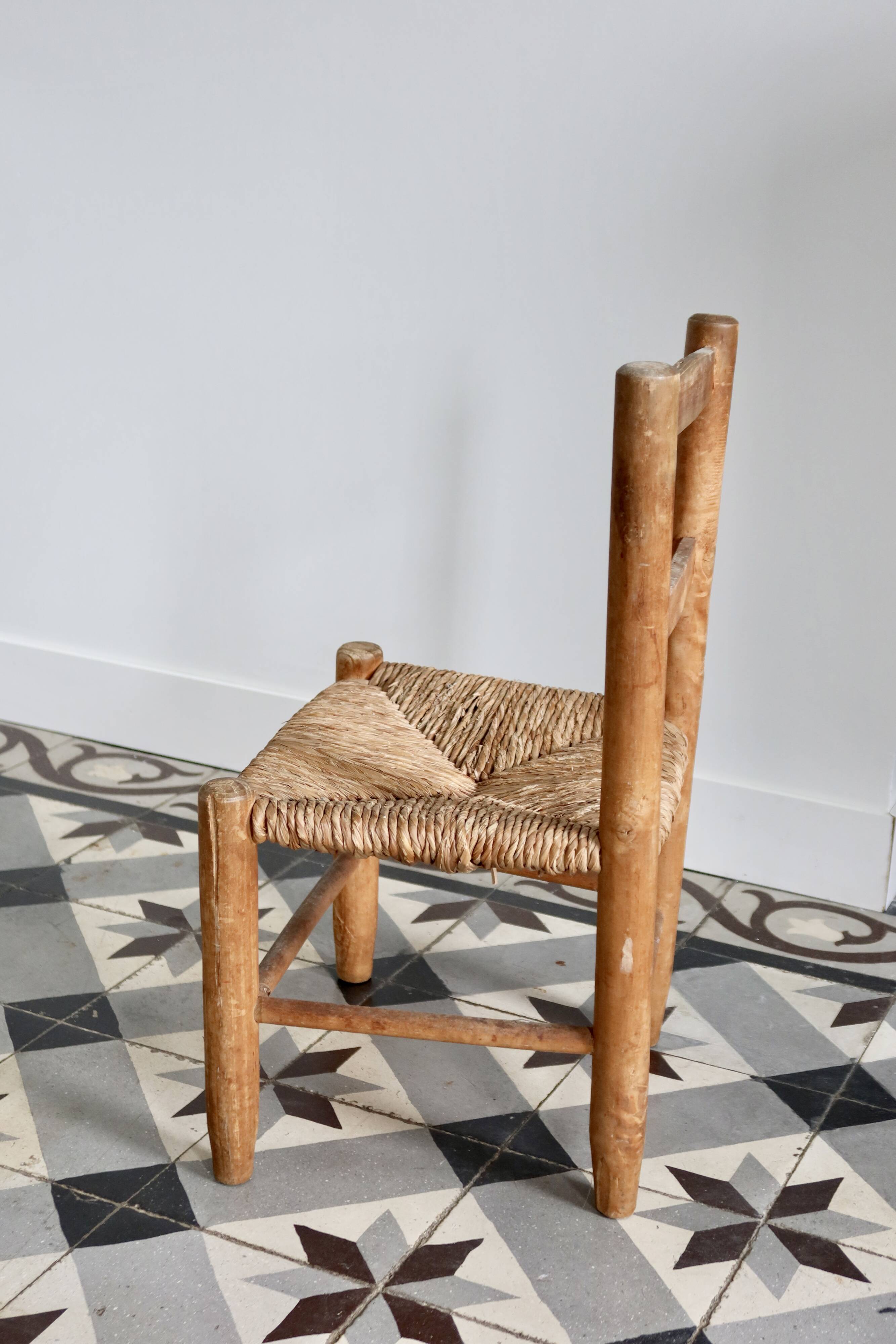 Antique wooden child's chair with a straw seat.