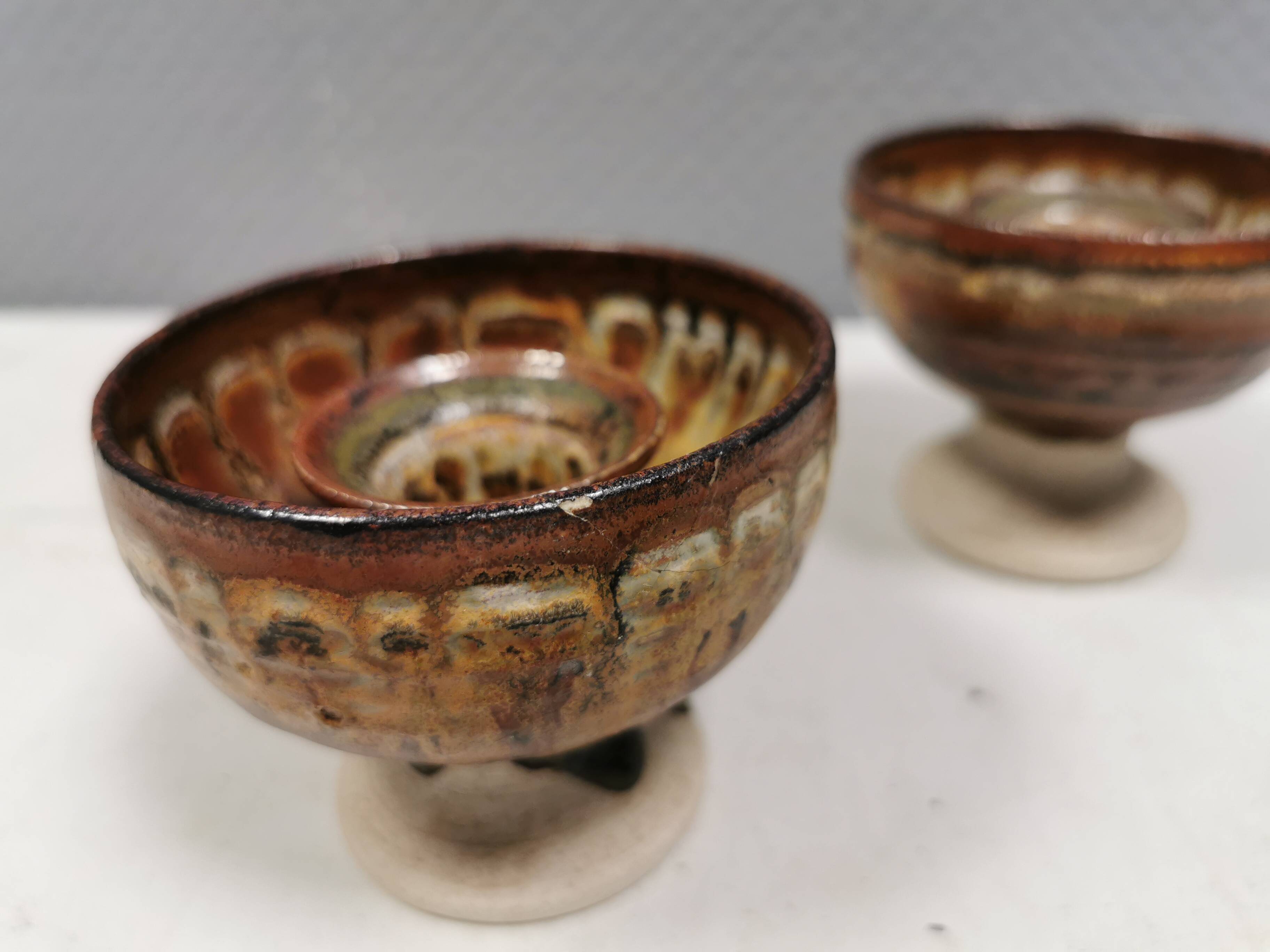 A set of ceramic candle holders in earthy colours.