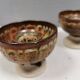 A set of ceramic candle holders in earthy colours.