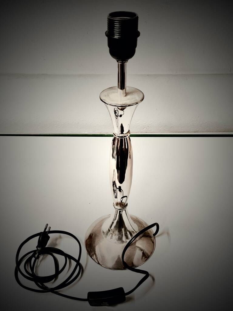 Contemporary table lamp in polished chrome with a conical fabric shade.