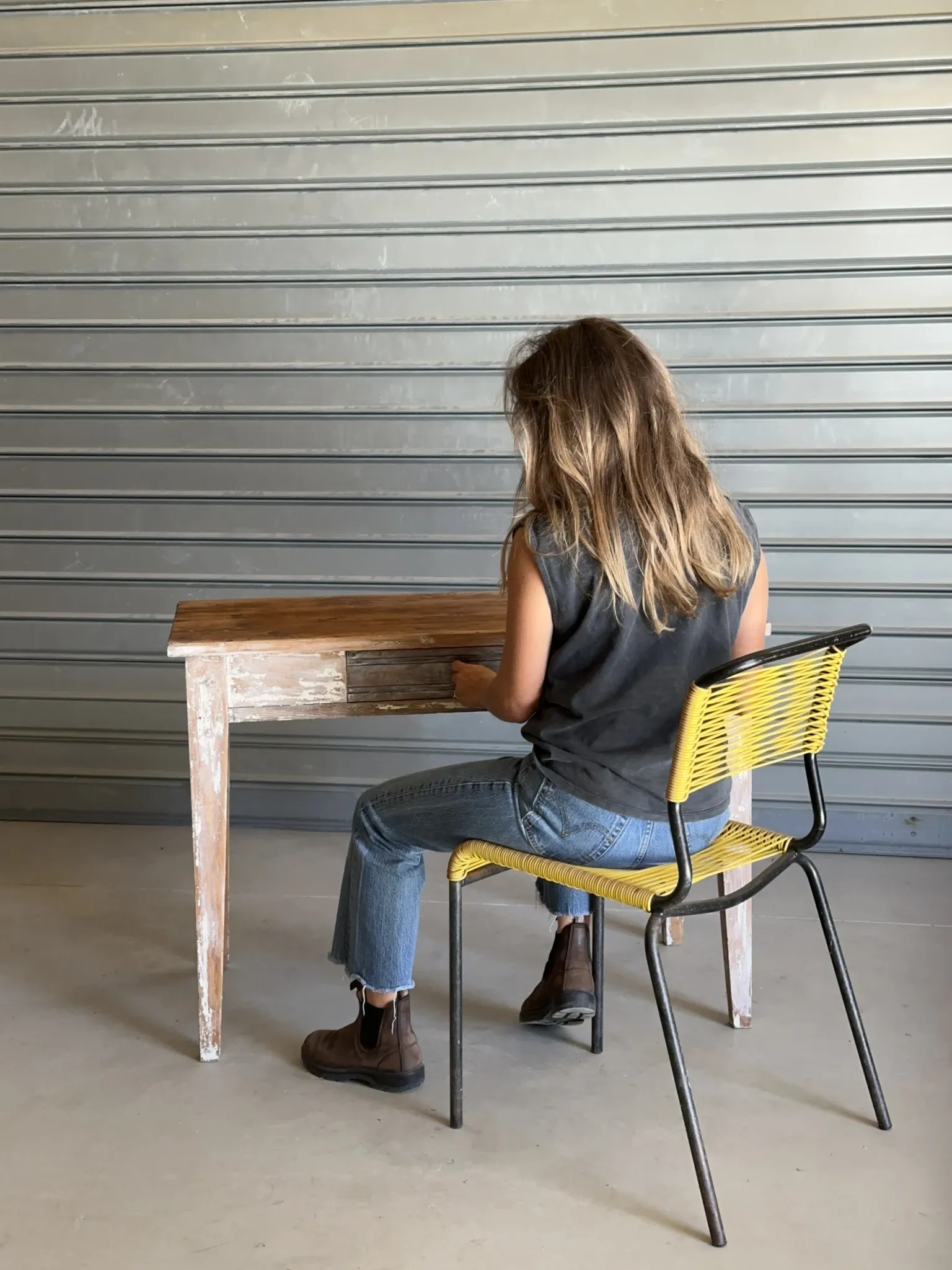 Vintage table made of raw wood with a distressed white base.
