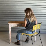 Vintage table made of raw wood with a distressed white base.