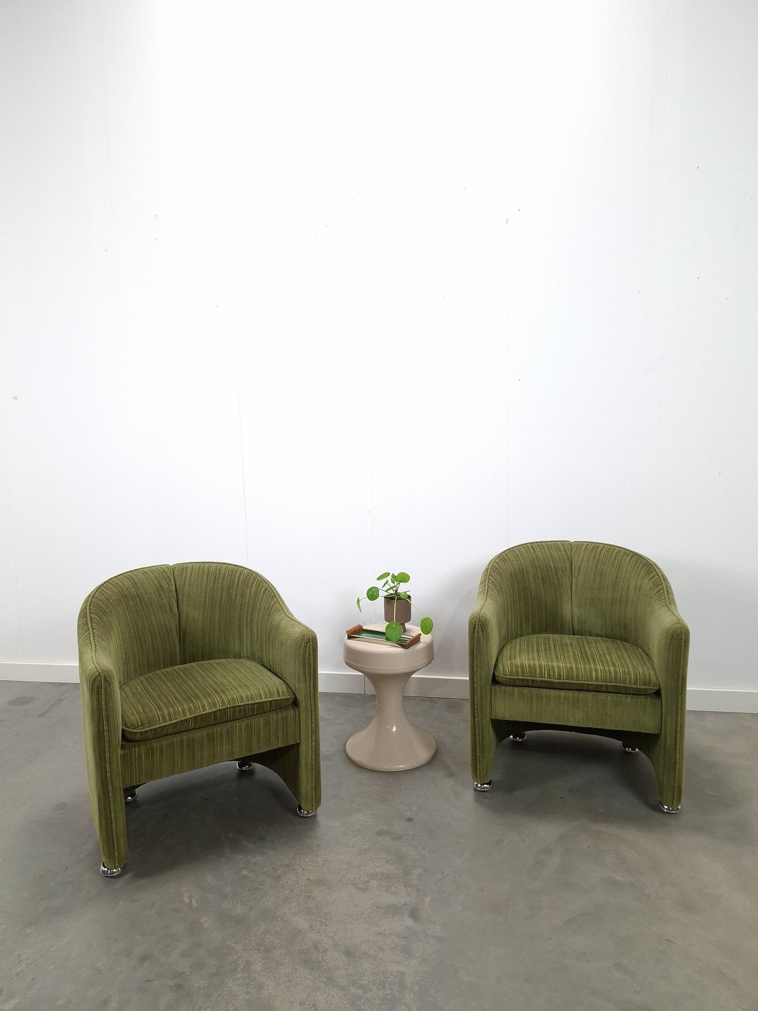 Chaises de cocktail vertes avec des roues chromées.