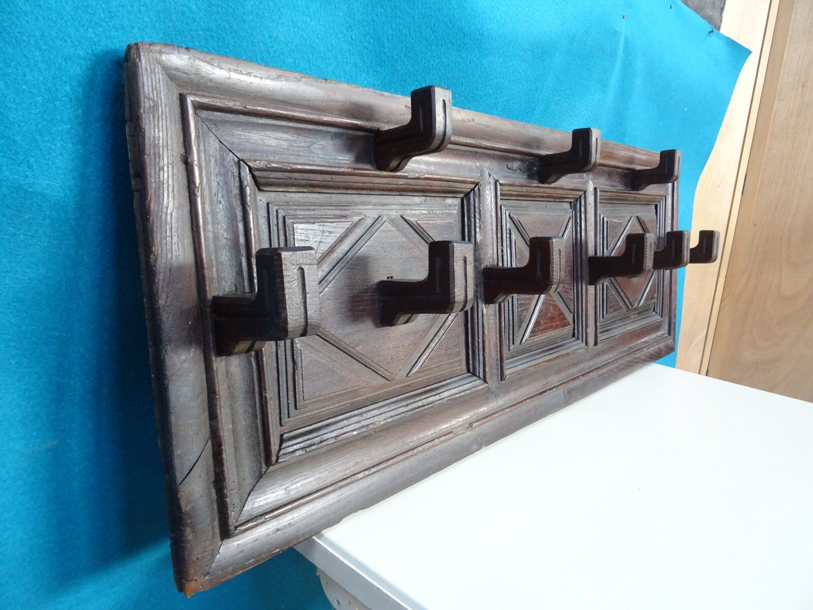Wall-mounted coat rack in solid oak with 9 hooks.