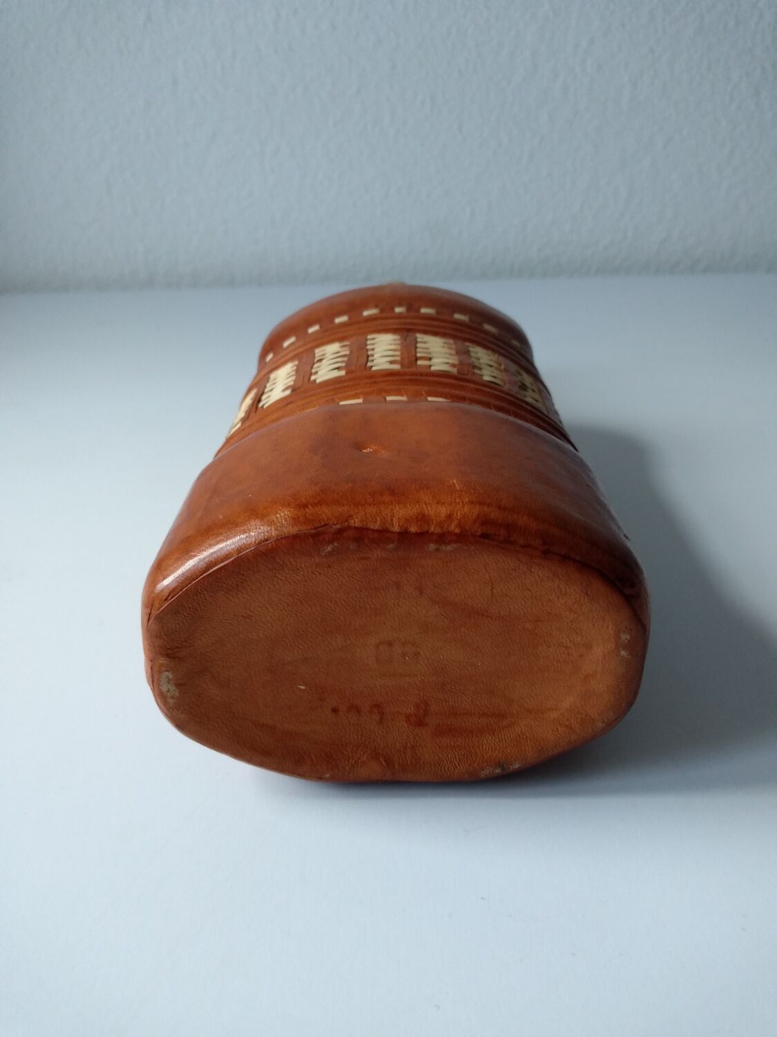 Vintage glass bottle covered with light brown leather and wicker