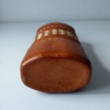 Vintage glass bottle covered with light brown leather and wicker