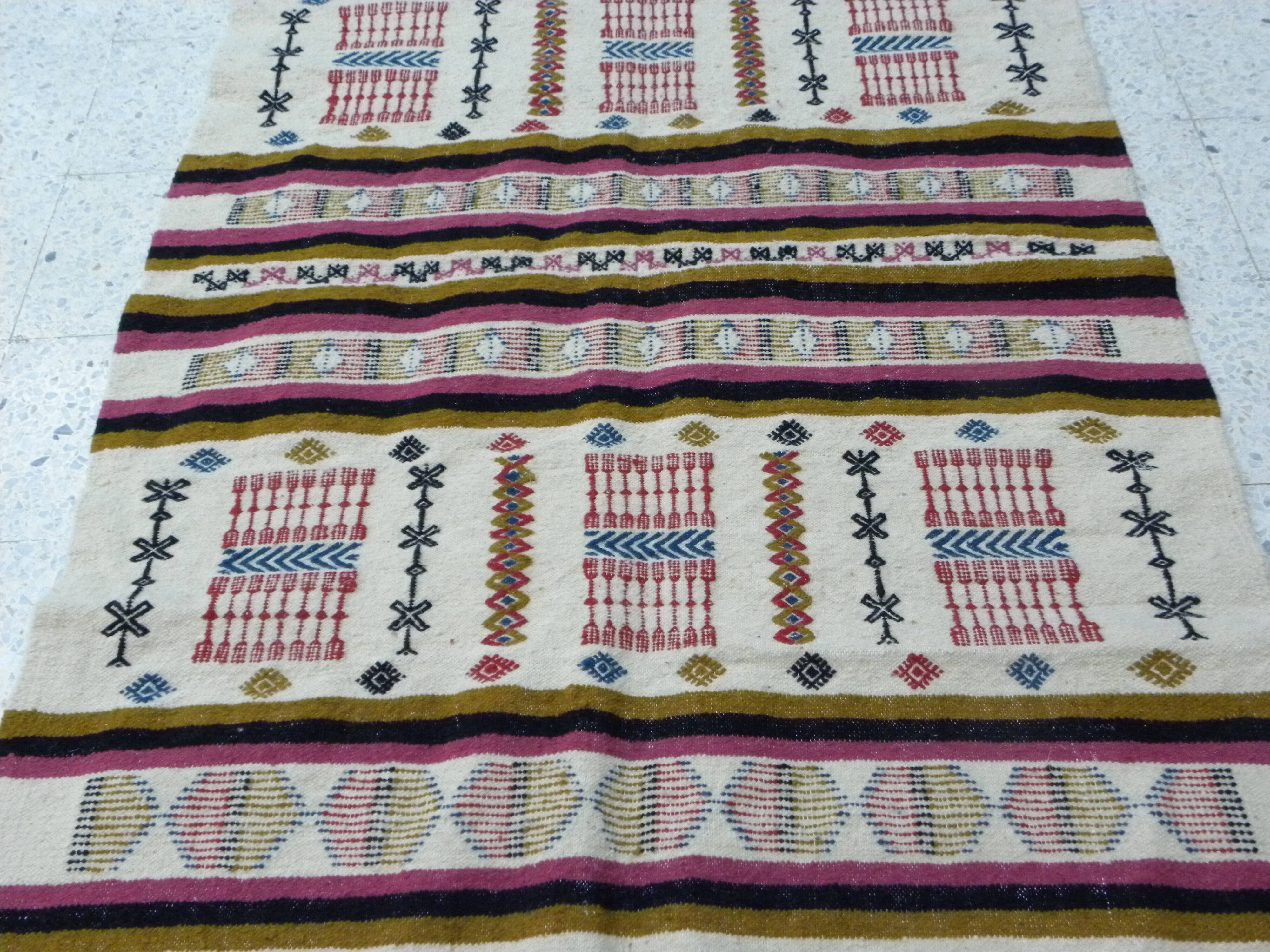 Handmade Berber kilim rug with multicoloured tribal motifs.