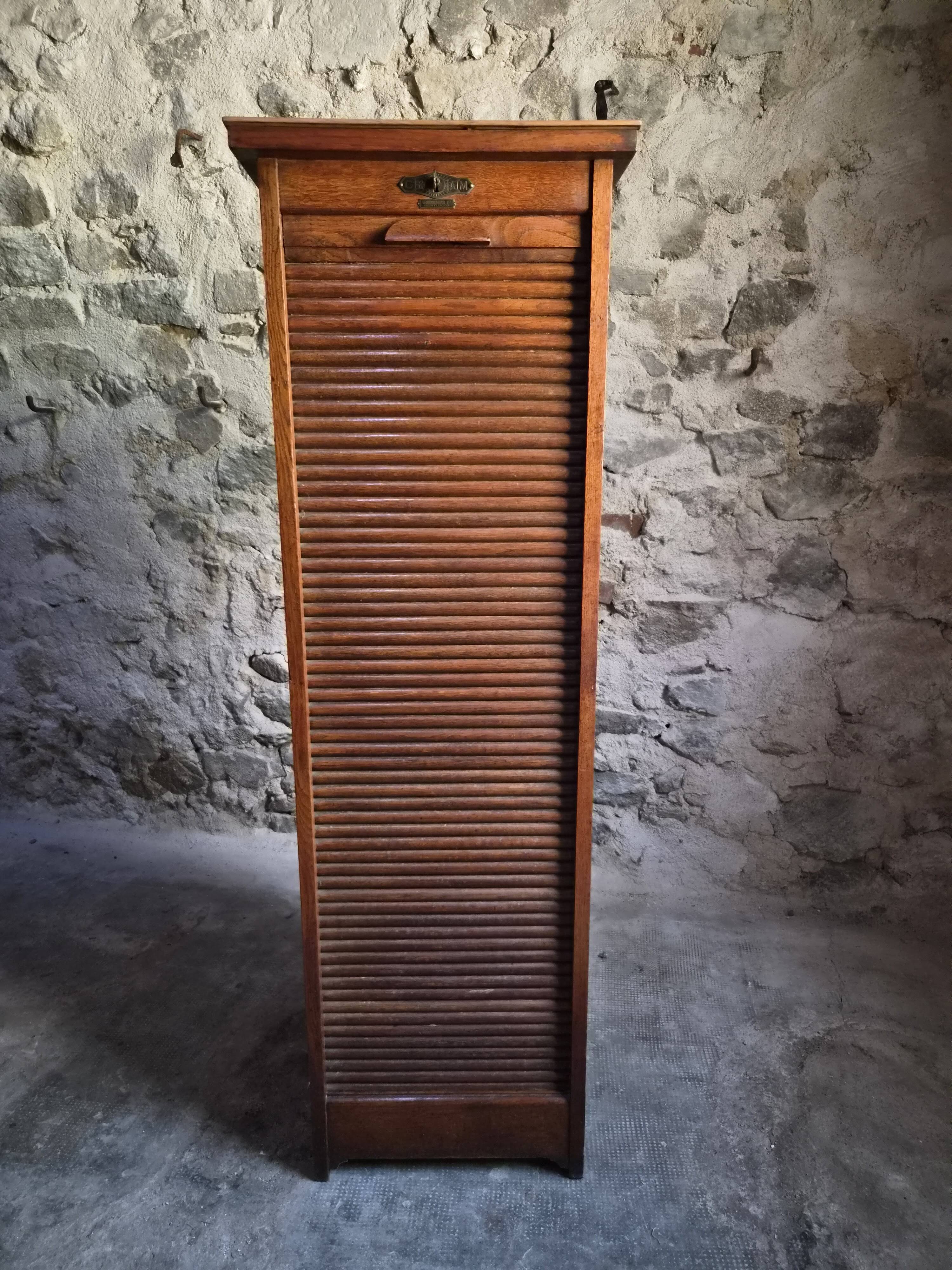 French antique wardrobe with curtain in oak, circa 1920–1930.