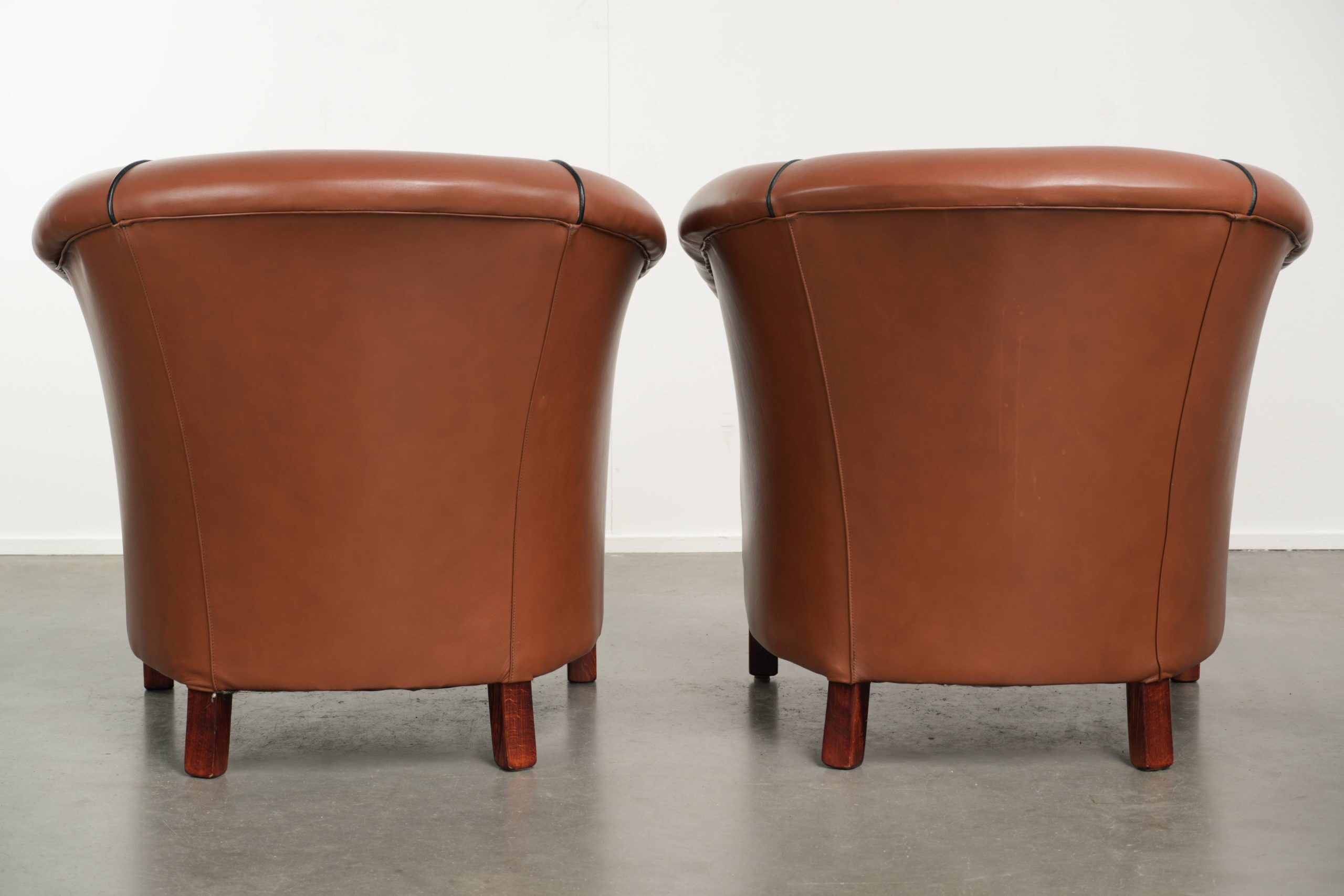 Ensemble de 2 fauteuils club en cuir de vache en bon état dans le style anglais.