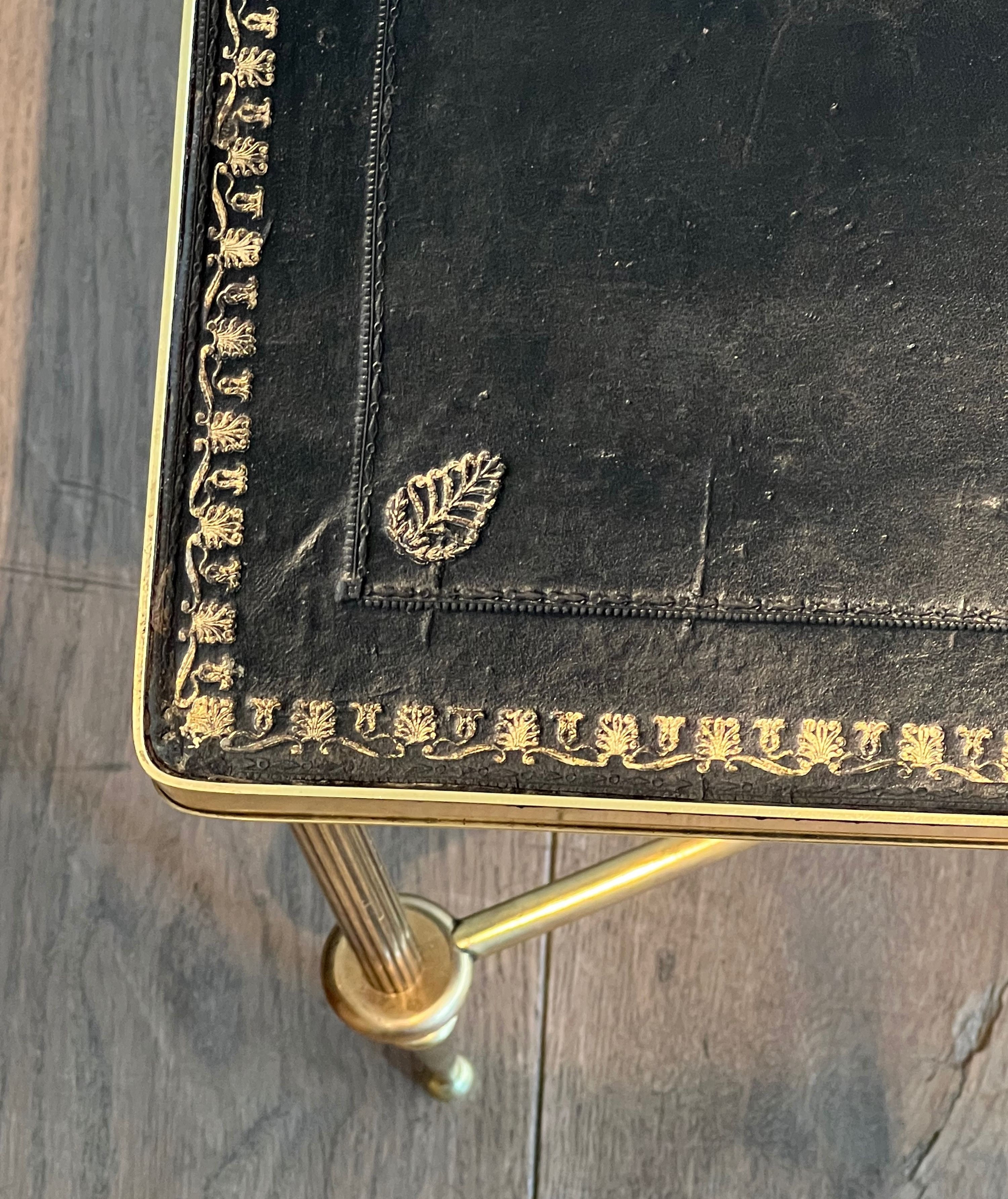 Neoclassical brass coffee table with a black leather top and golden borders from Maison Jansen.