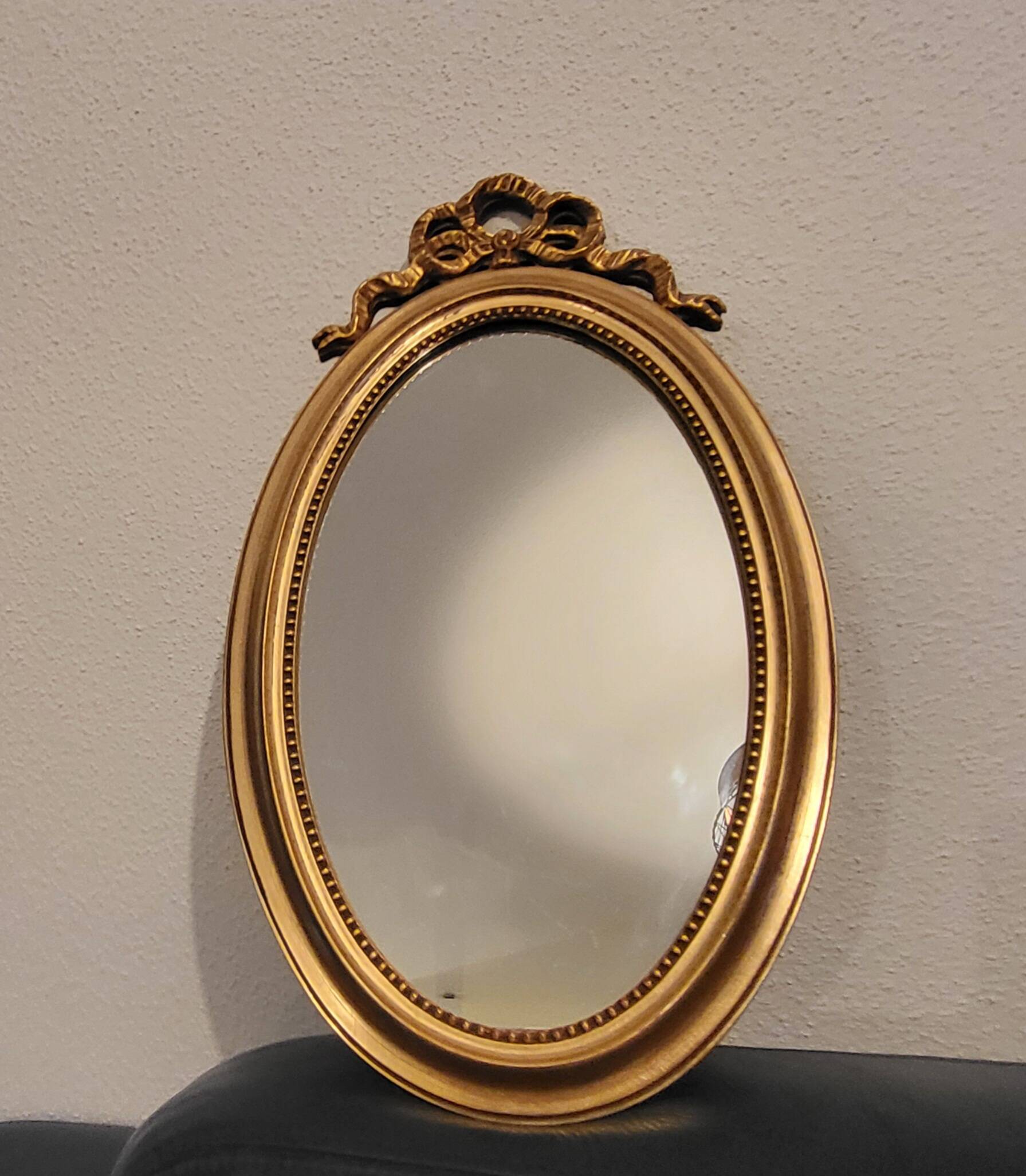 Oval mirror with golden wooden knot
