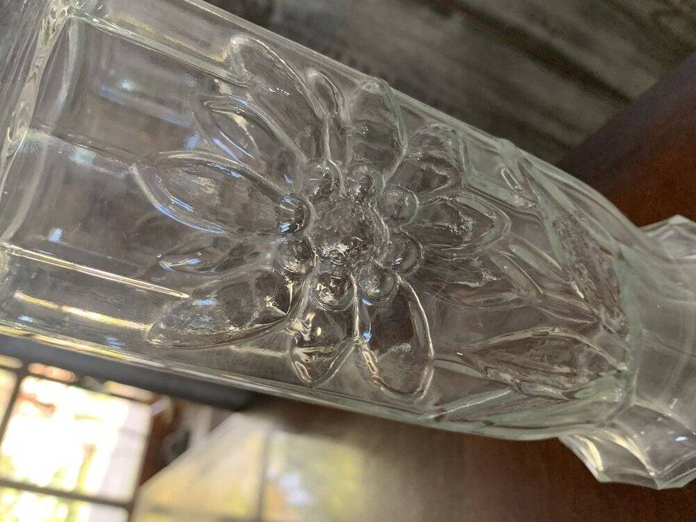 Transparent glass vase with relief floral decoration from the 1980s, fluted neck and polygonal base.