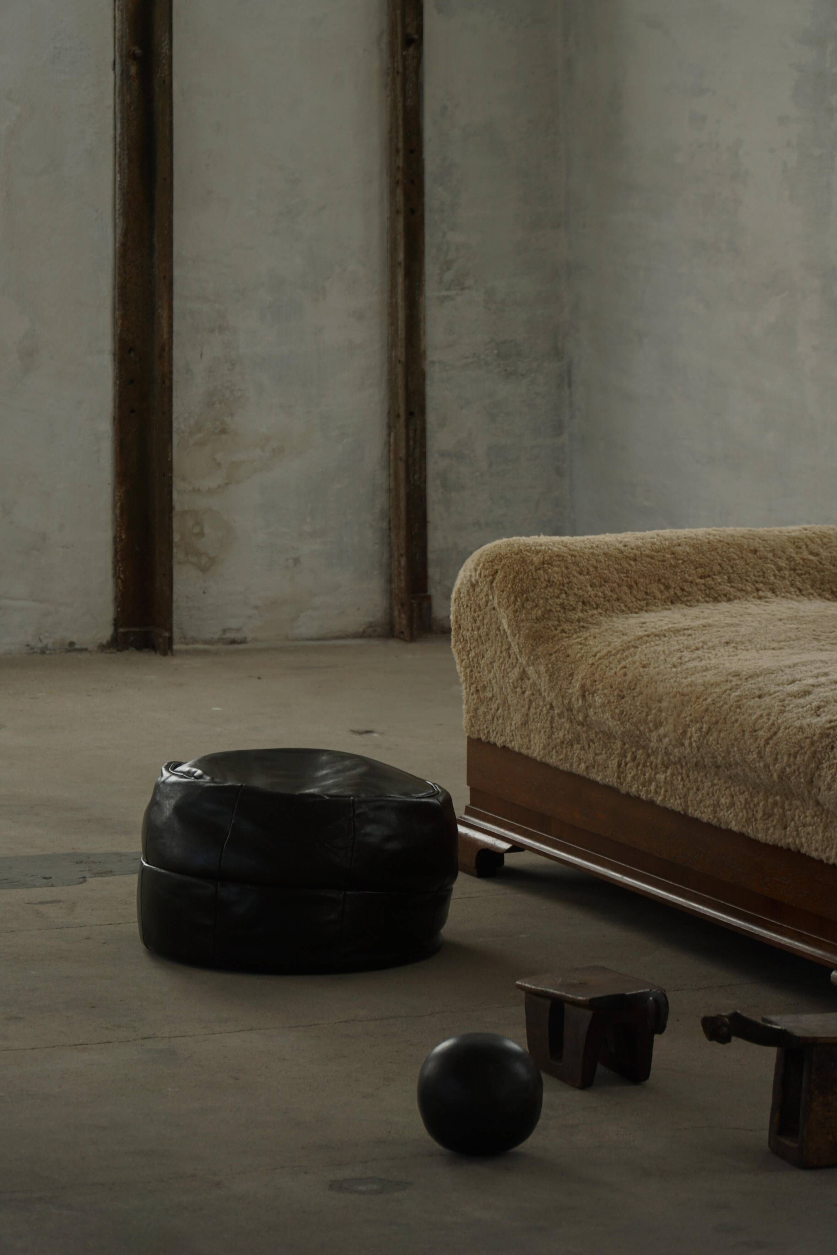 Vintage black leather pouf/ottoman with a rounded shape, French mid 20th Century.