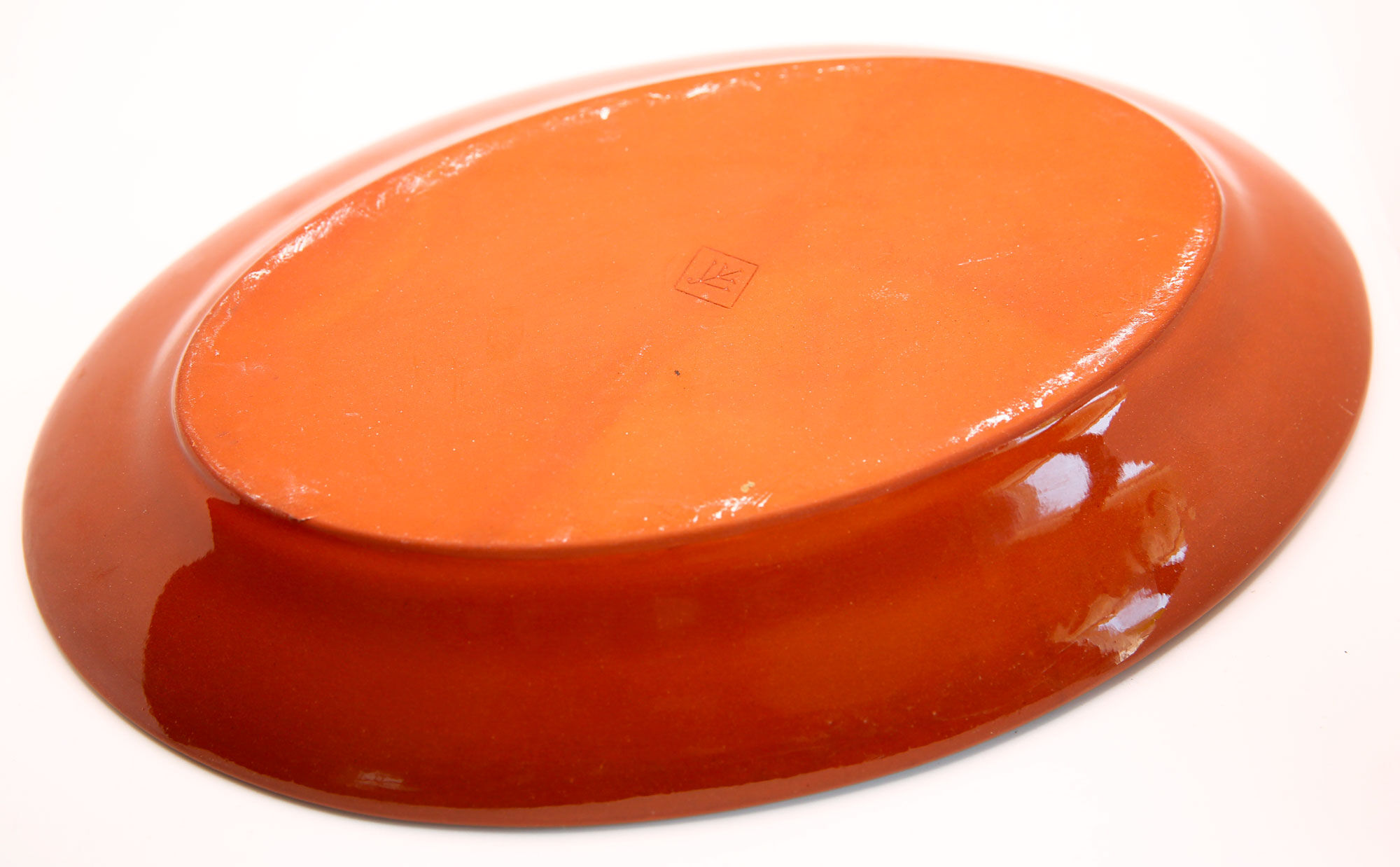 Portuguese XL dish in orange enamelled clay with unbleached flowers and green leaves