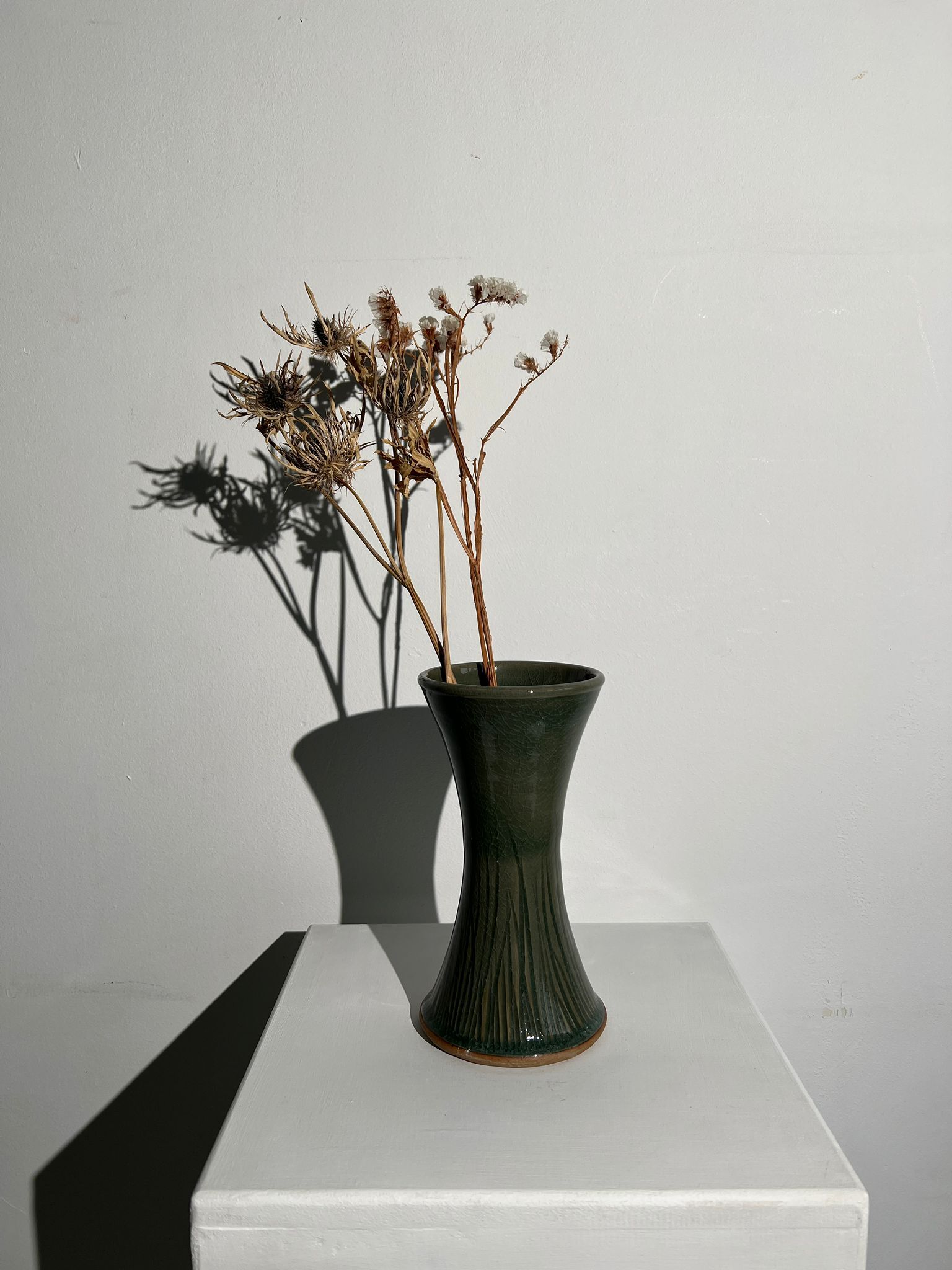 Dark green handcrafted vase with glazed ceramic grass blades