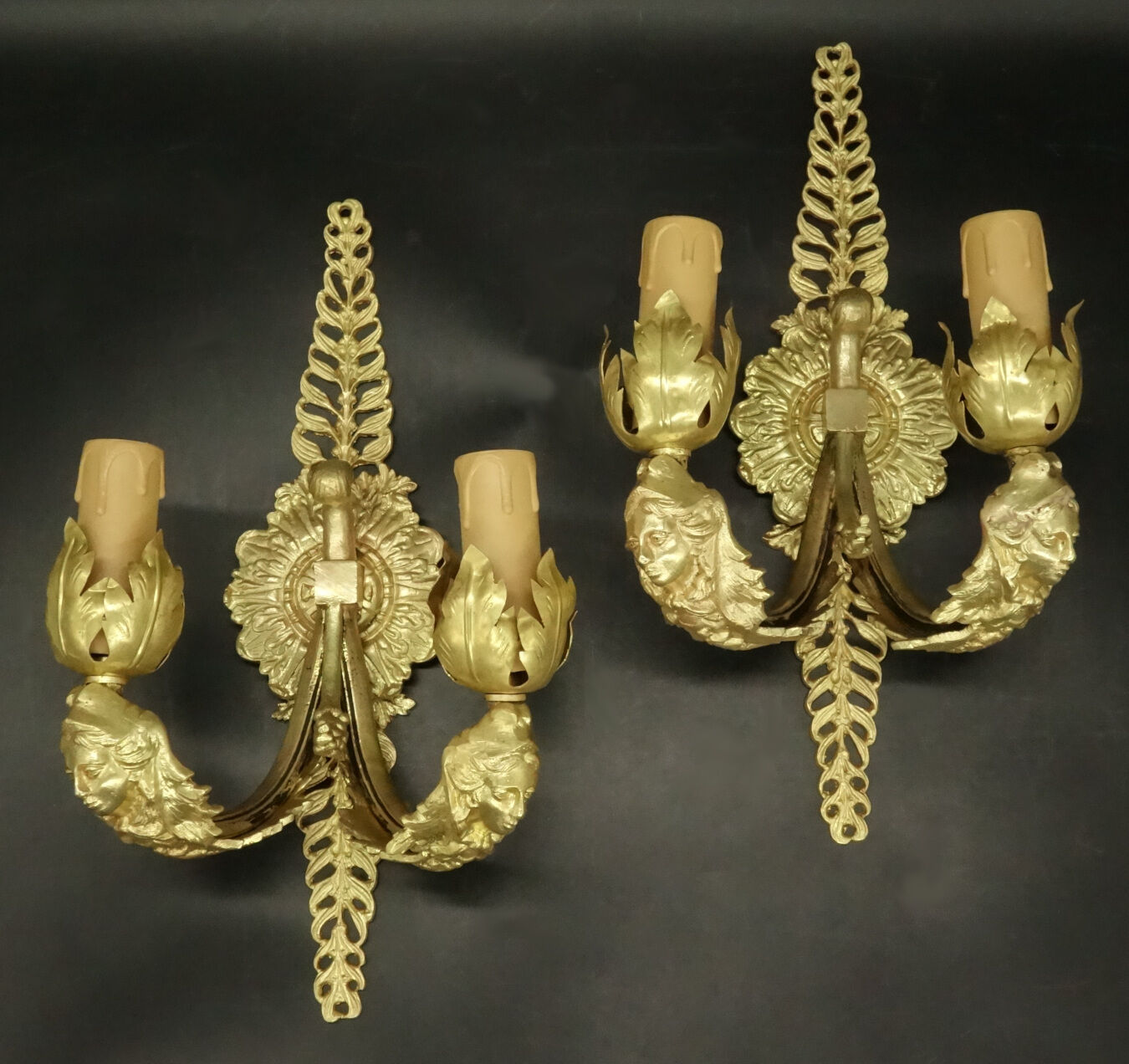 Pair of wall sconces with mask motifs in Empire style from the early 1900s - gilded bronze.