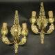 Pair of wall sconces with mask motifs in Empire style from the early 1900s - gilded bronze.