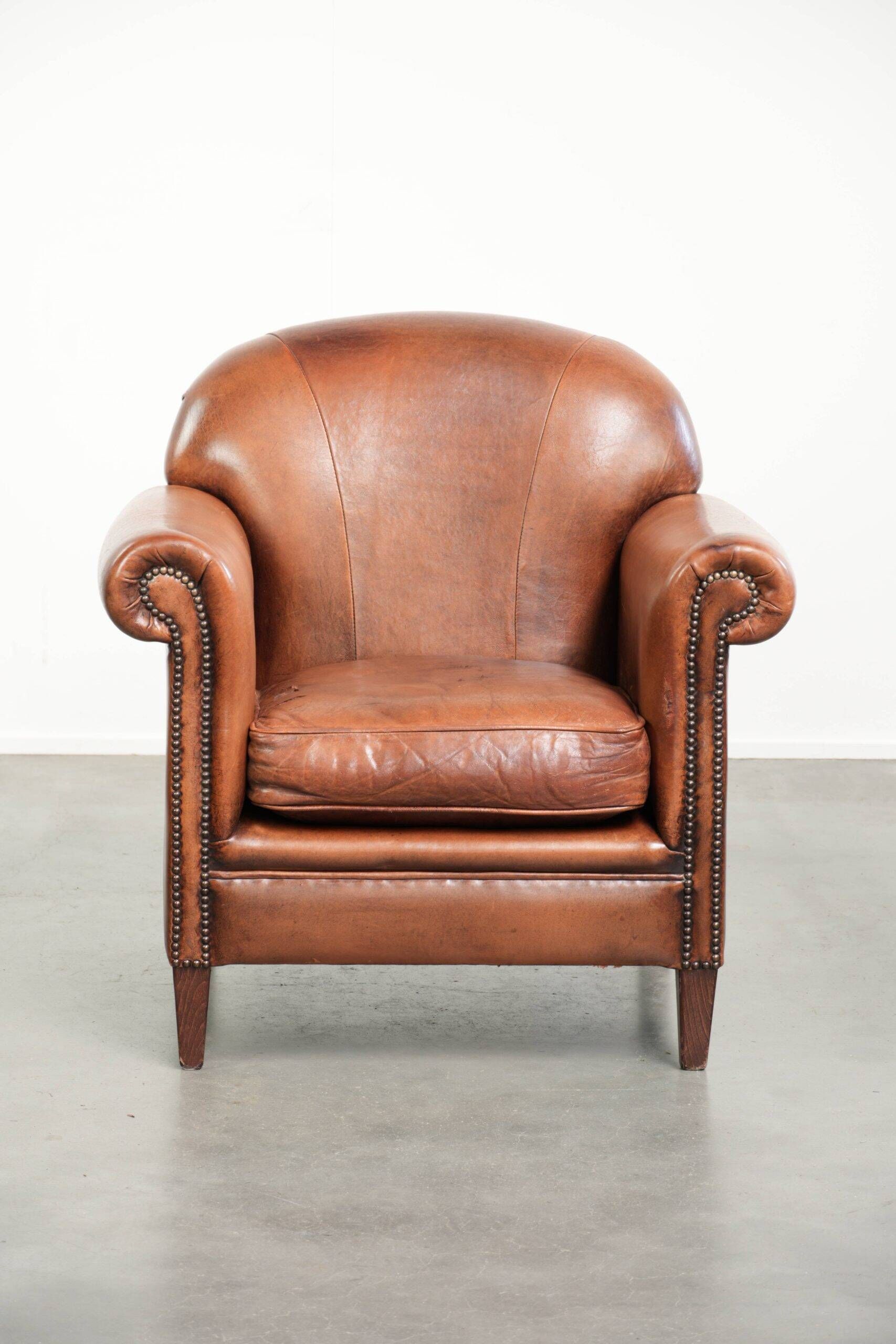 Comfortable vintage sheepskin armchair finished with decorative nails