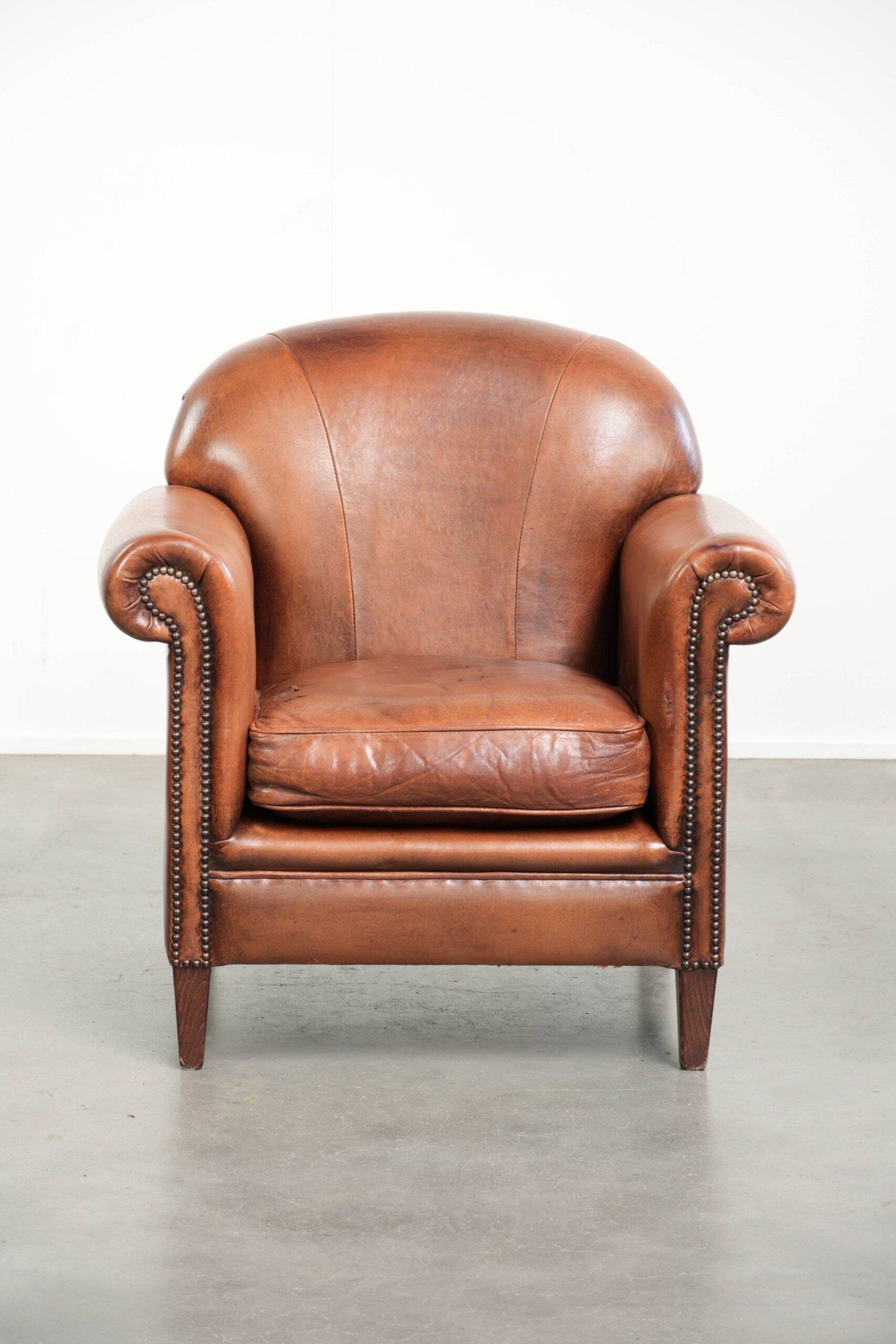 Comfortable vintage sheepskin armchair finished with decorative nails