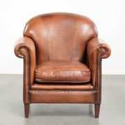 Comfortable vintage sheepskin armchair finished with decorative nails