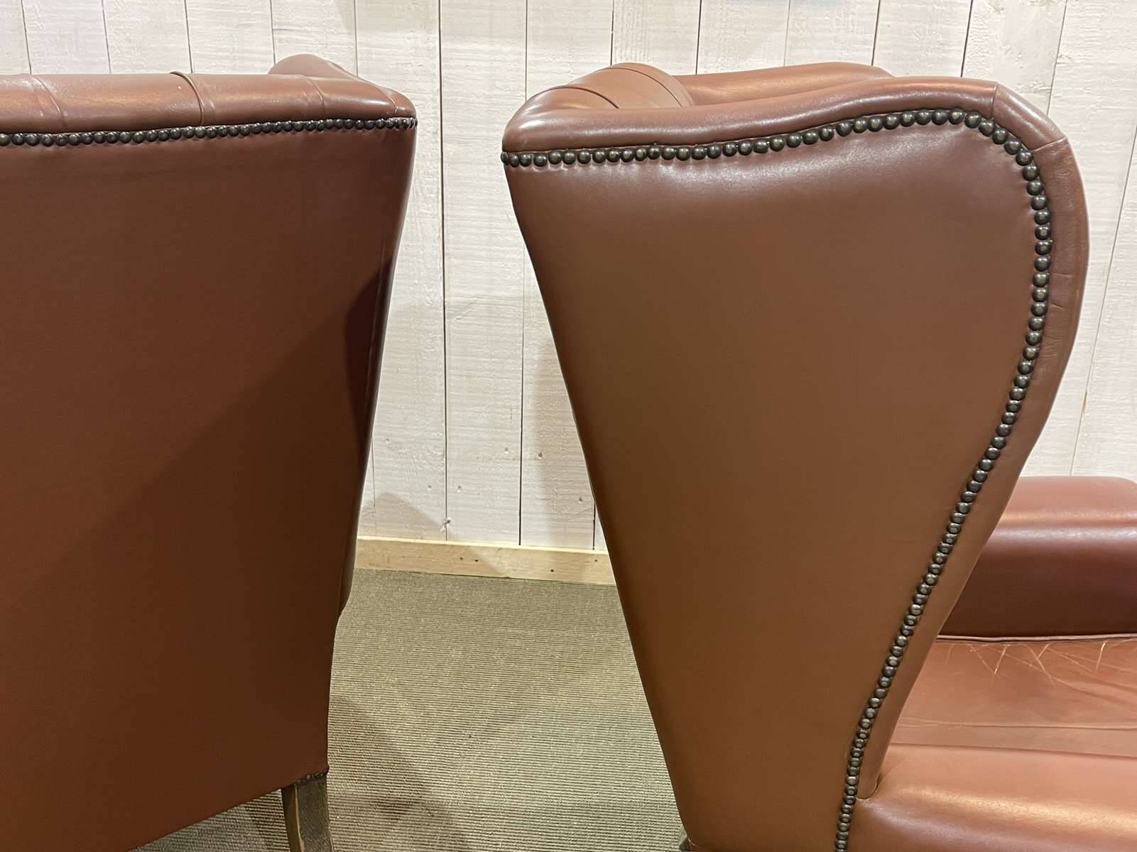 Pair of brown leather wingback Chesterfield armchairs from the 1970s.