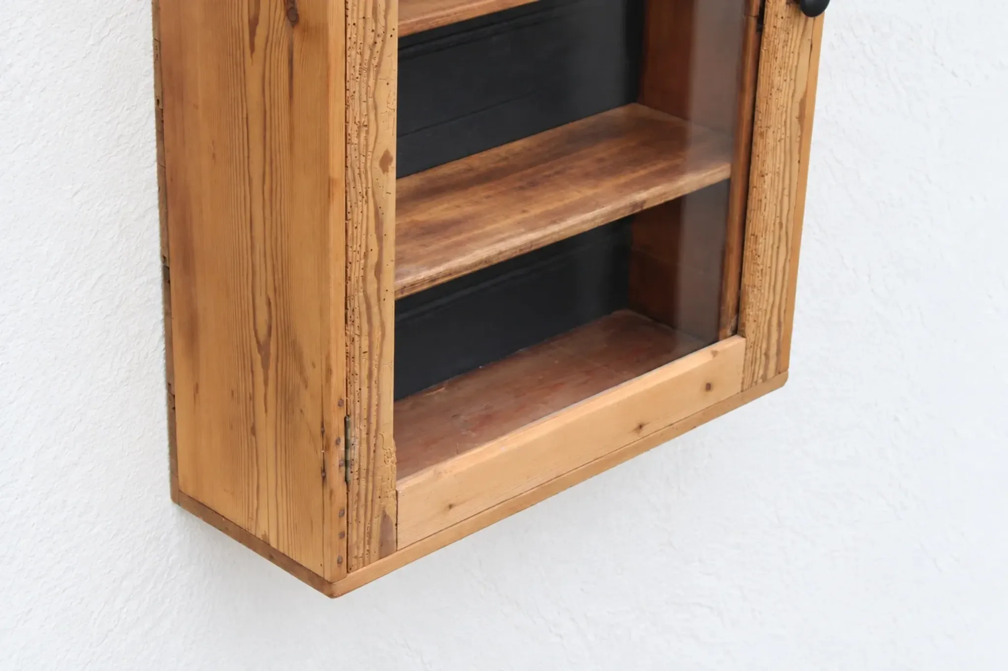 Antique wall display cabinet in natural wood and black – small glass-fronted collector's piece.
